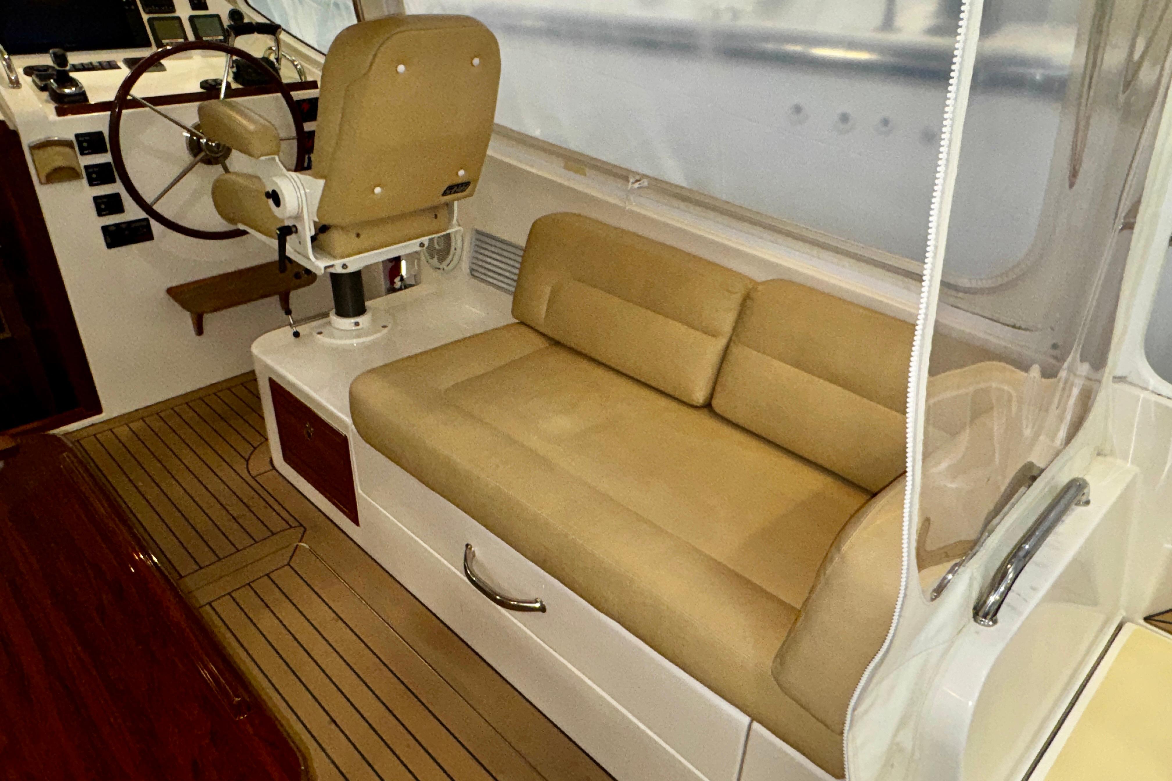 Interior of 2015 MJM 36z Express boat with beige seating and steering wheel.