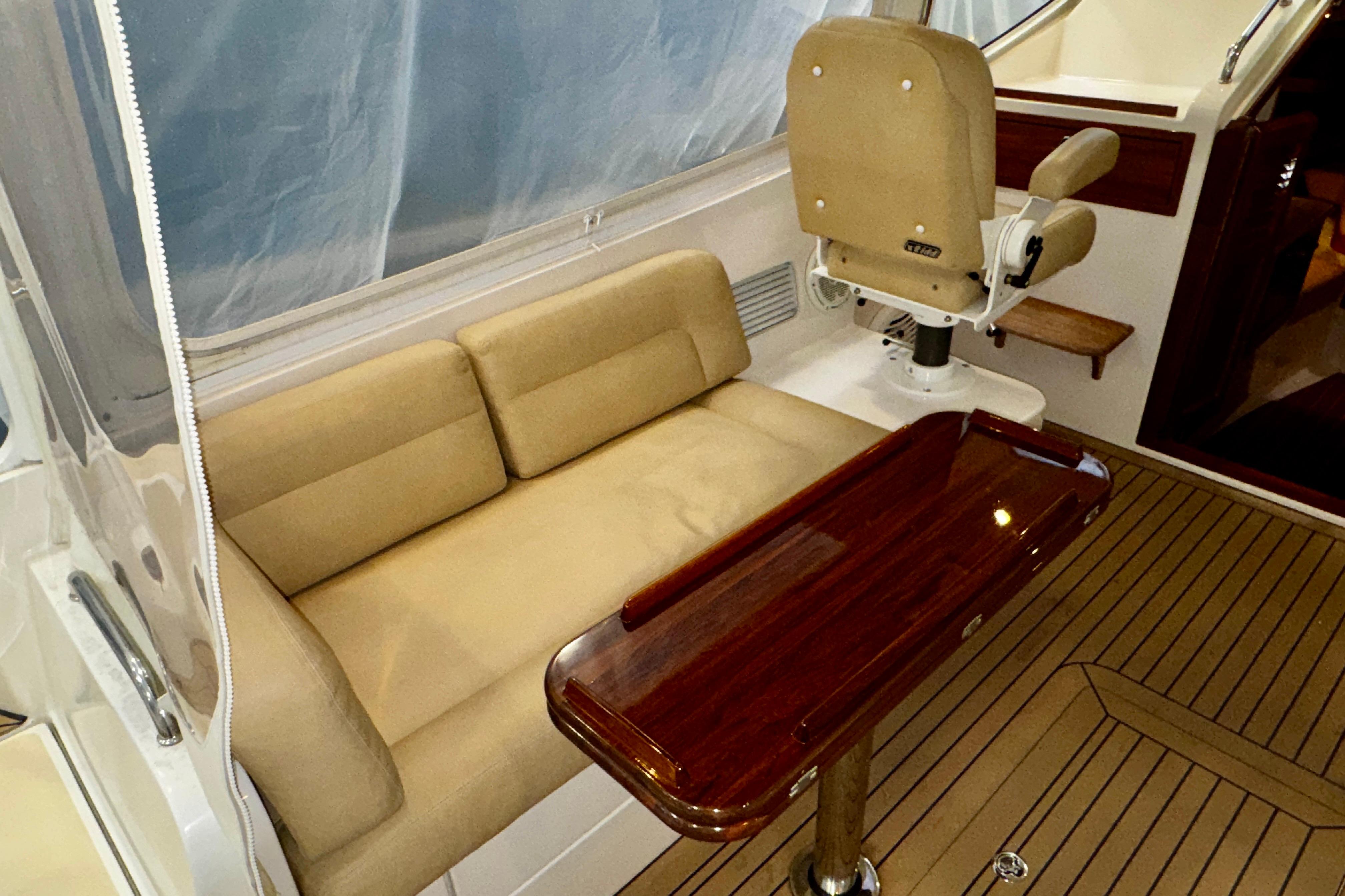 2015 MJM 36z Express yacht interior with beige seating and polished wood table.