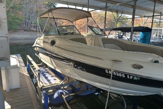 2002 Sea Ray 240 Sundeck boat docked under a covered marina.