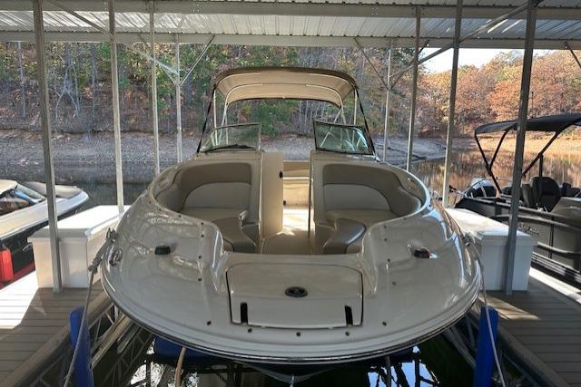 2002 Sea Ray 240 Sundeck boat docked under a covered marina.