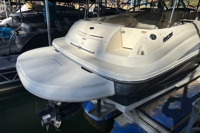 2002 Sea Ray 240 Sundeck boat docked, rear view showing swim platform and seating area.