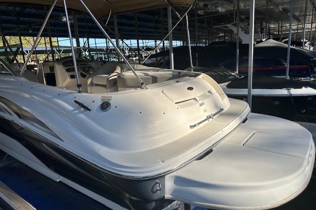 2002 Sea Ray 240 Sundeck boat docked in a marina, showcasing spacious deck design.