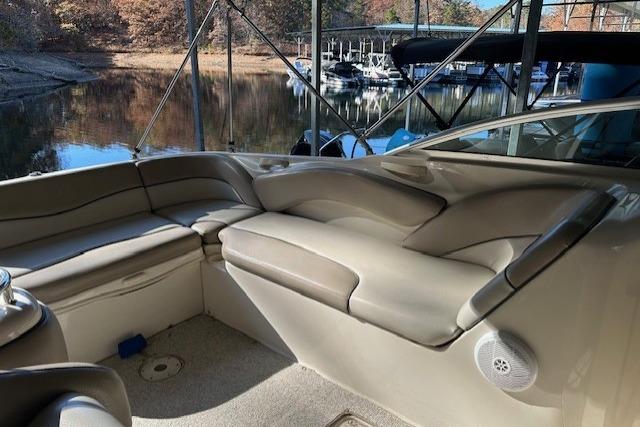 Interior of 2002 Sea Ray 240 Sundeck boat with beige seating and waterfront view.