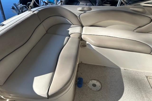 2002 Sea Ray 240 Sundeck interior seating with beige upholstery and cup holders.