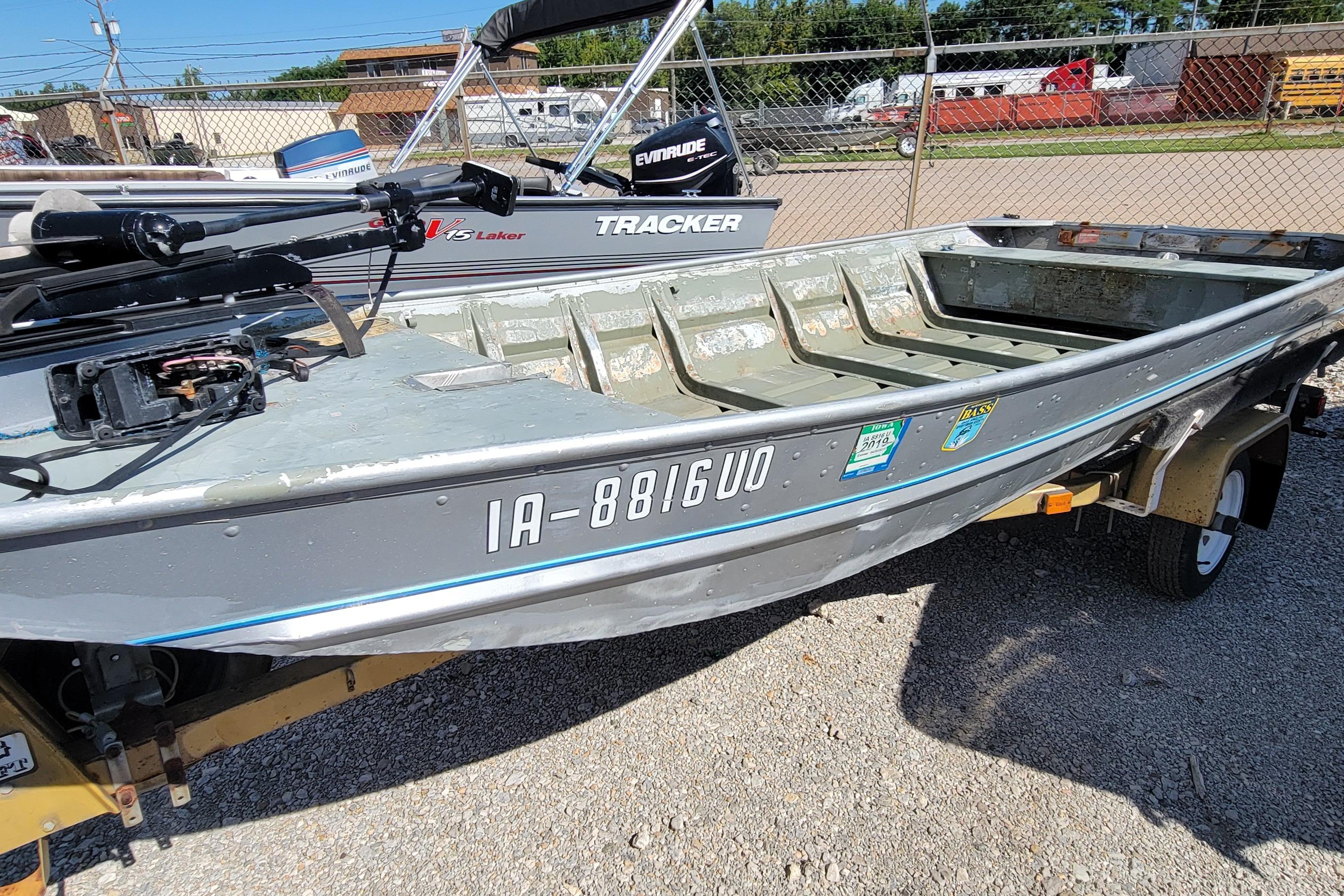 1973 Monark 14 Jon boat on trailer, parked outdoors, with visible registration number.