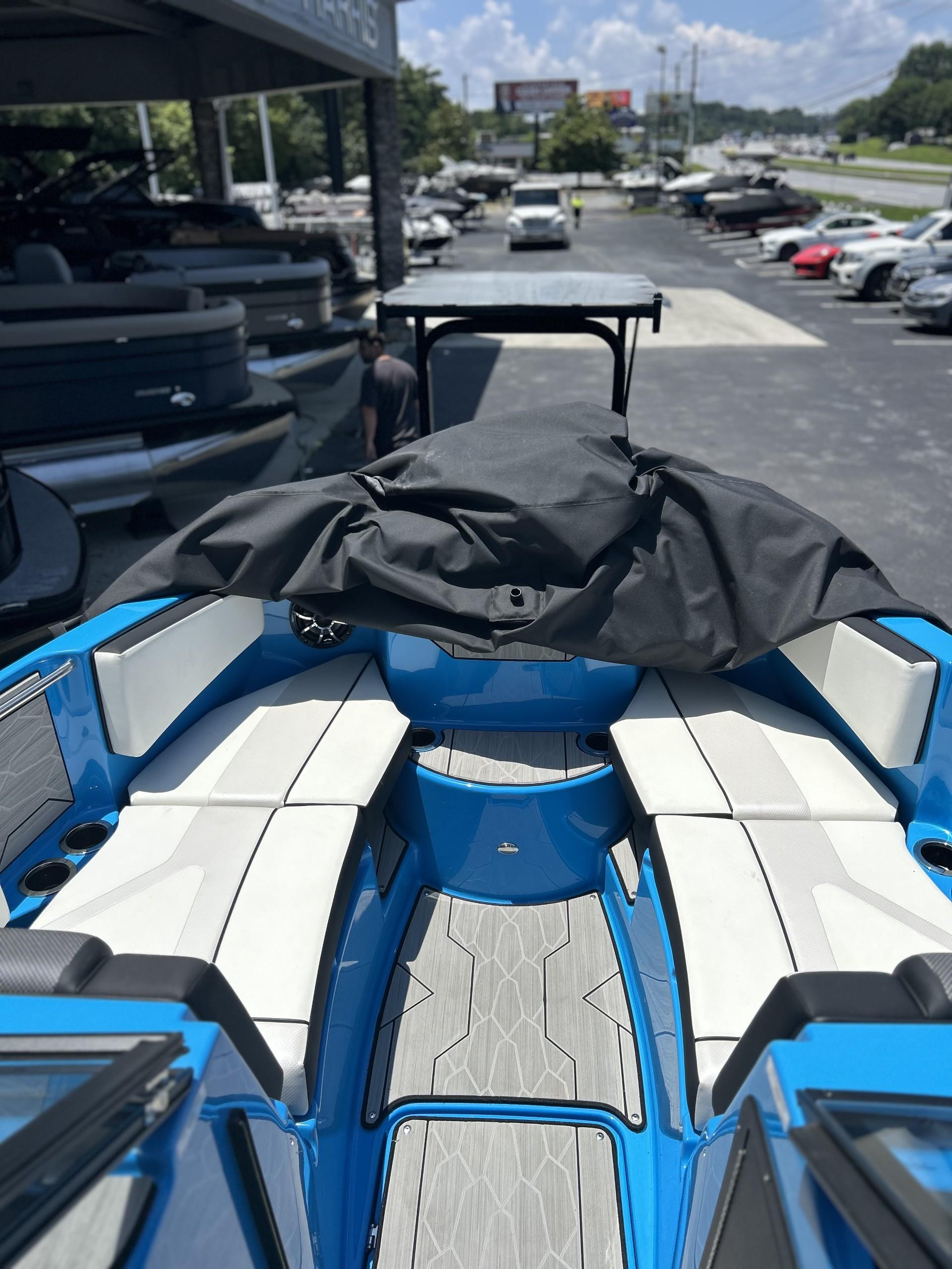 2023 Yamaha Boats 222 XD interior with blue and white seating, docked at a marina.