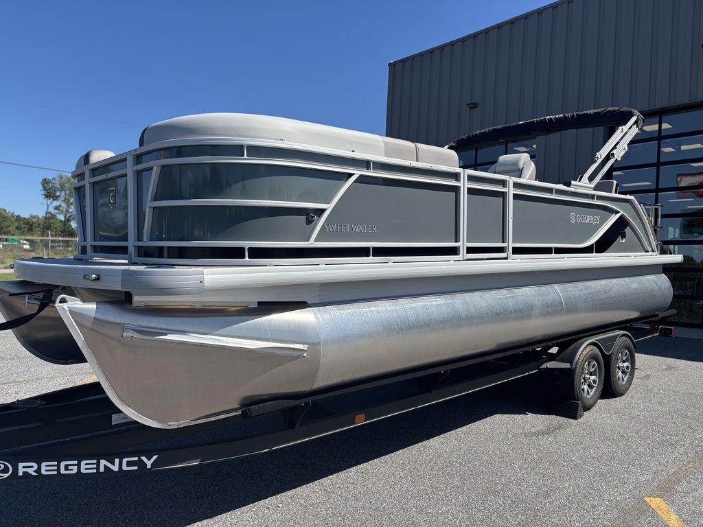 2025 Godfrey Sweetwater 2286 SFLC pontoon boat on trailer, parked outdoors.