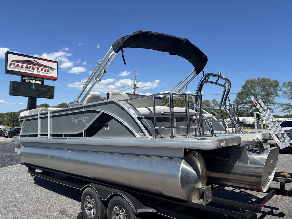 2025 Godfrey Sweetwater 2286 SFLC pontoon boat on trailer under clear blue sky.