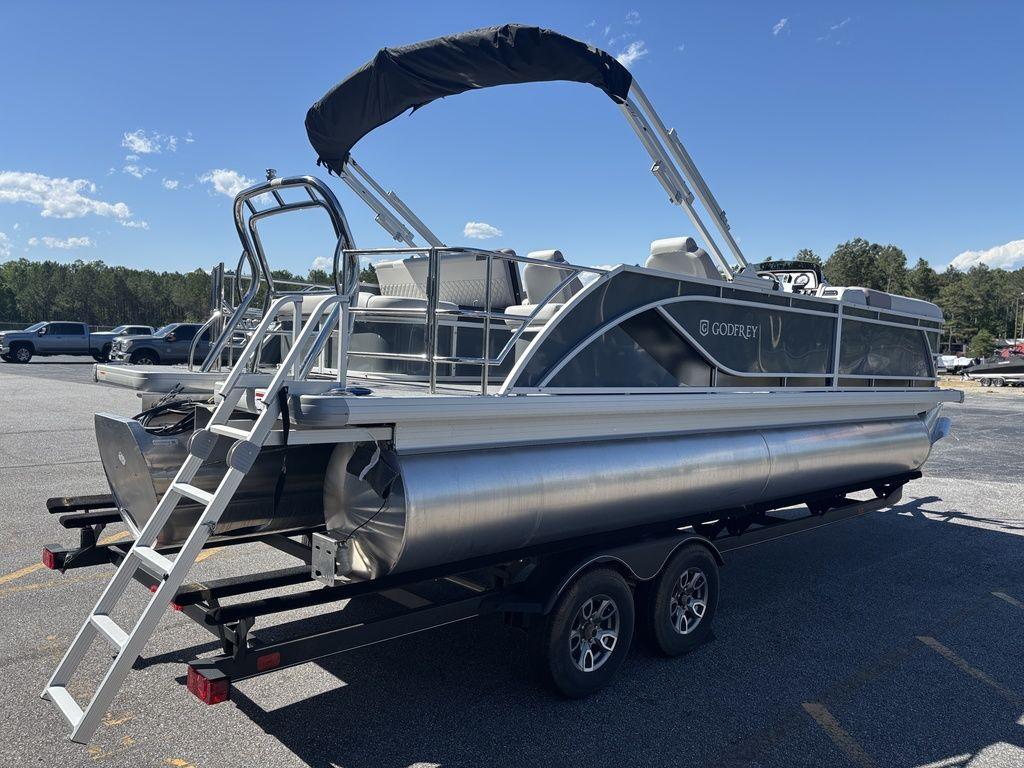 2025 Godfrey Sweetwater 2286 SFLC pontoon boat on trailer, parked outdoors.