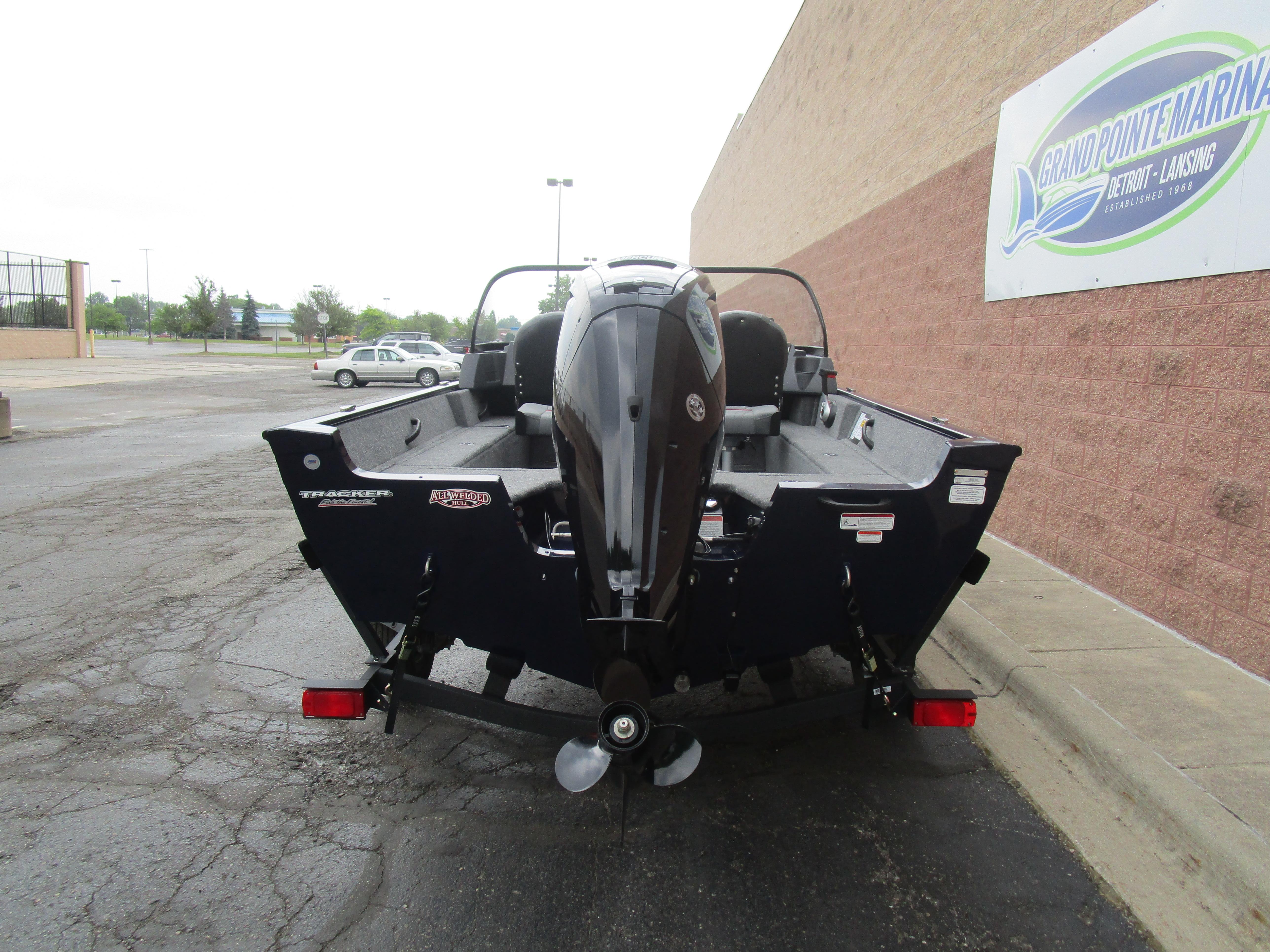 2025 Tracker Pro Guide V16 WT boat, rear view, parked near a marina.