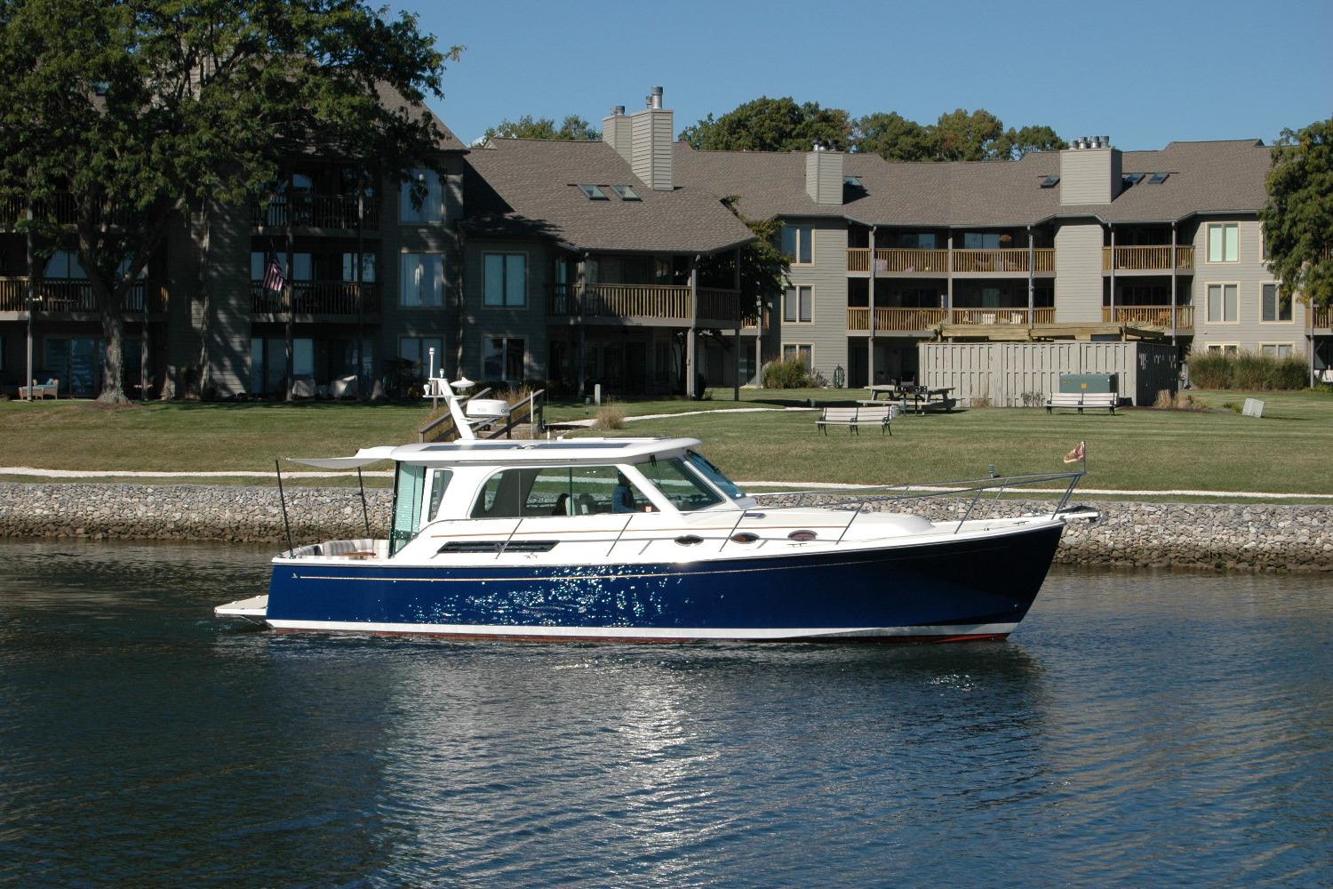 2015 Back Cove 37 boat cruising near waterfront homes.