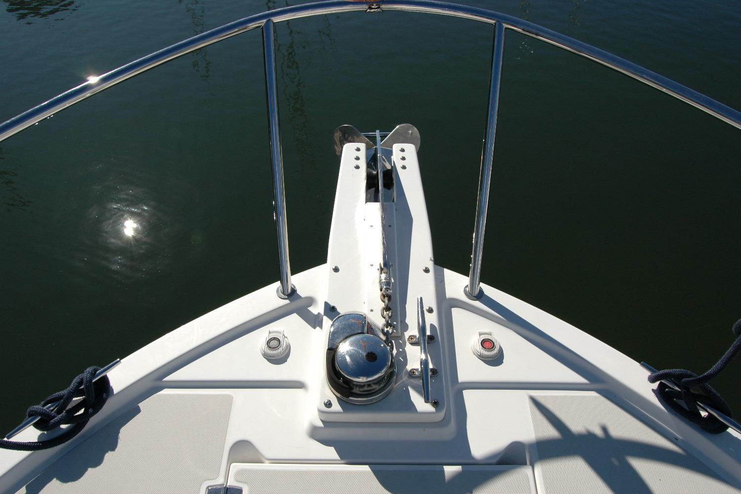 Bow of 2015 Back Cove 37 boat with anchor and railing in sunlight.