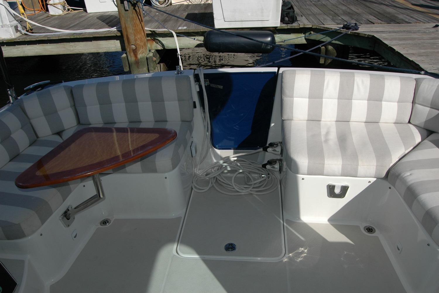 2015 Back Cove 37 boat interior with striped seating and wooden table.