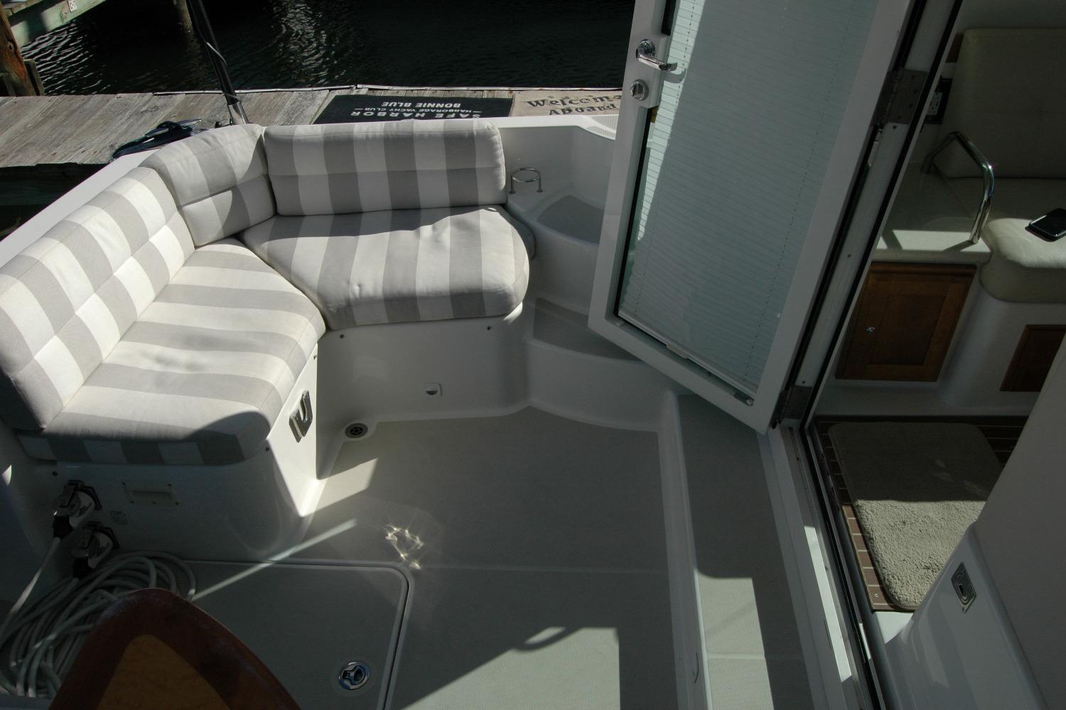 2015 Back Cove 37 boat interior with striped seating and open door to cabin.