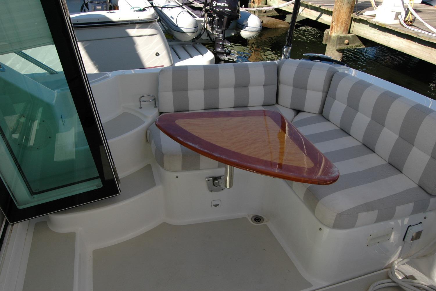2015 Back Cove 37 boat with striped seating and triangular wooden table.