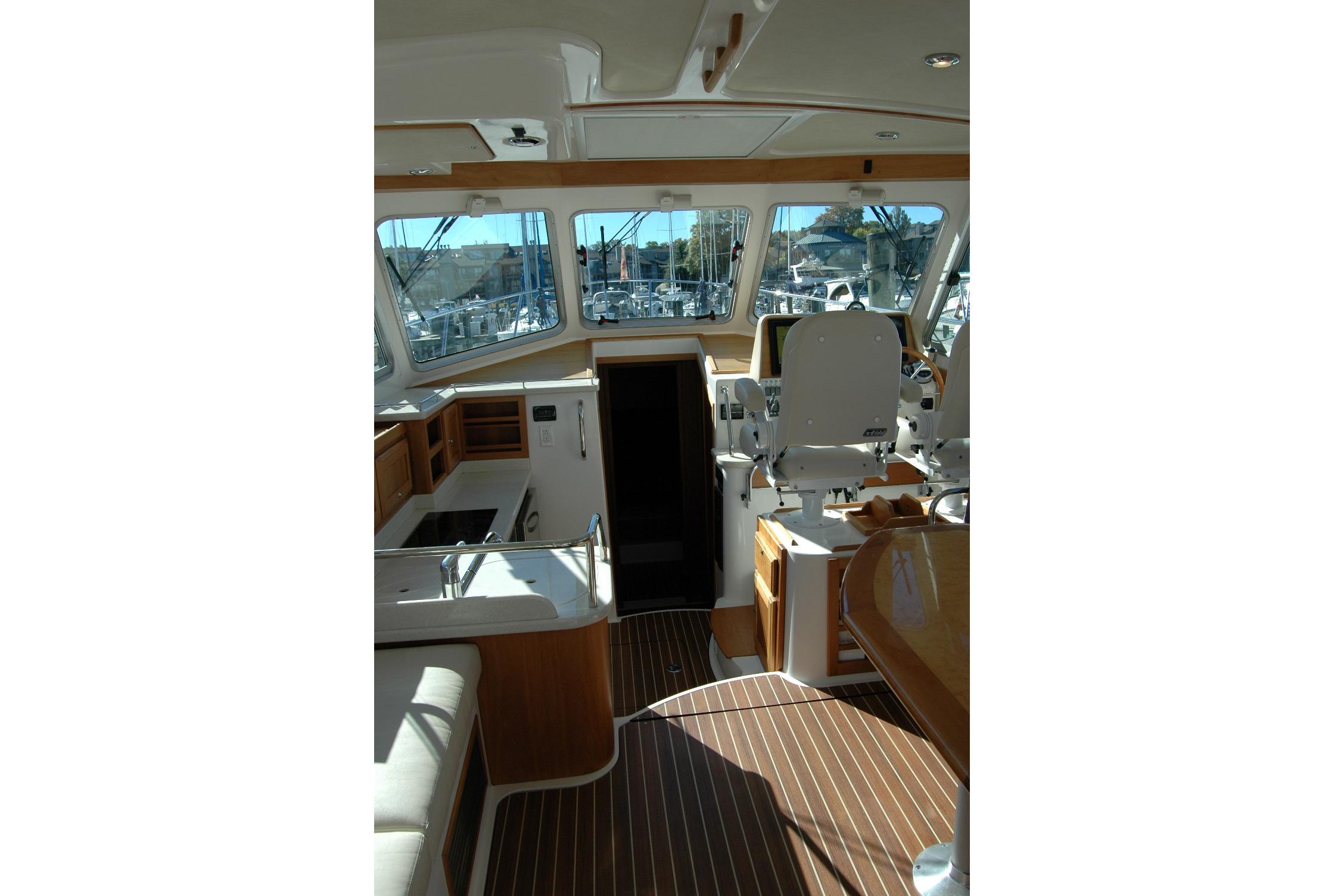 Interior of 2015 Back Cove 37 yacht with helm, seating, and wooden flooring.