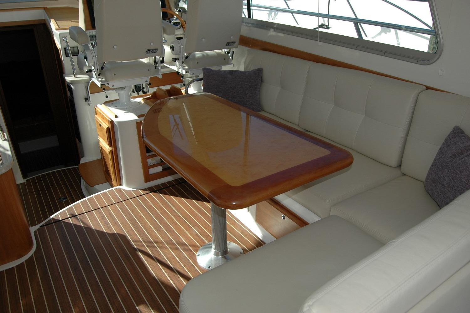 2015 Back Cove 37 yacht interior with cushioned seating and wooden table.