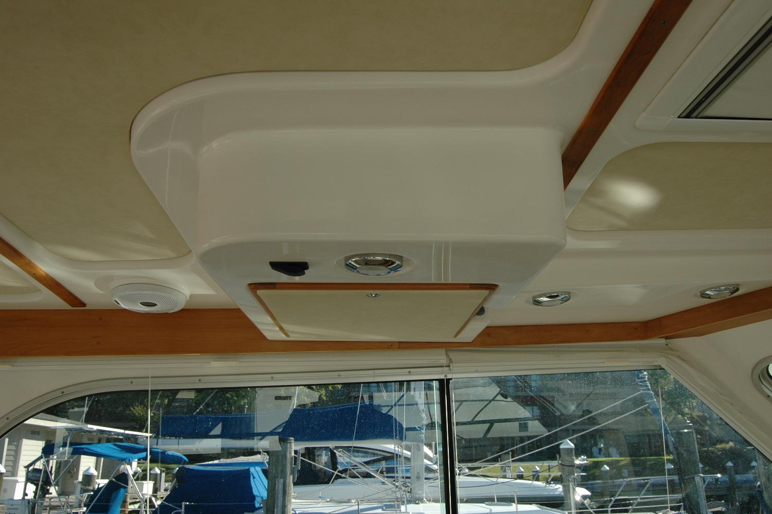Interior ceiling of a 2015 Back Cove 37 boat with wood accents and lighting fixtures.
