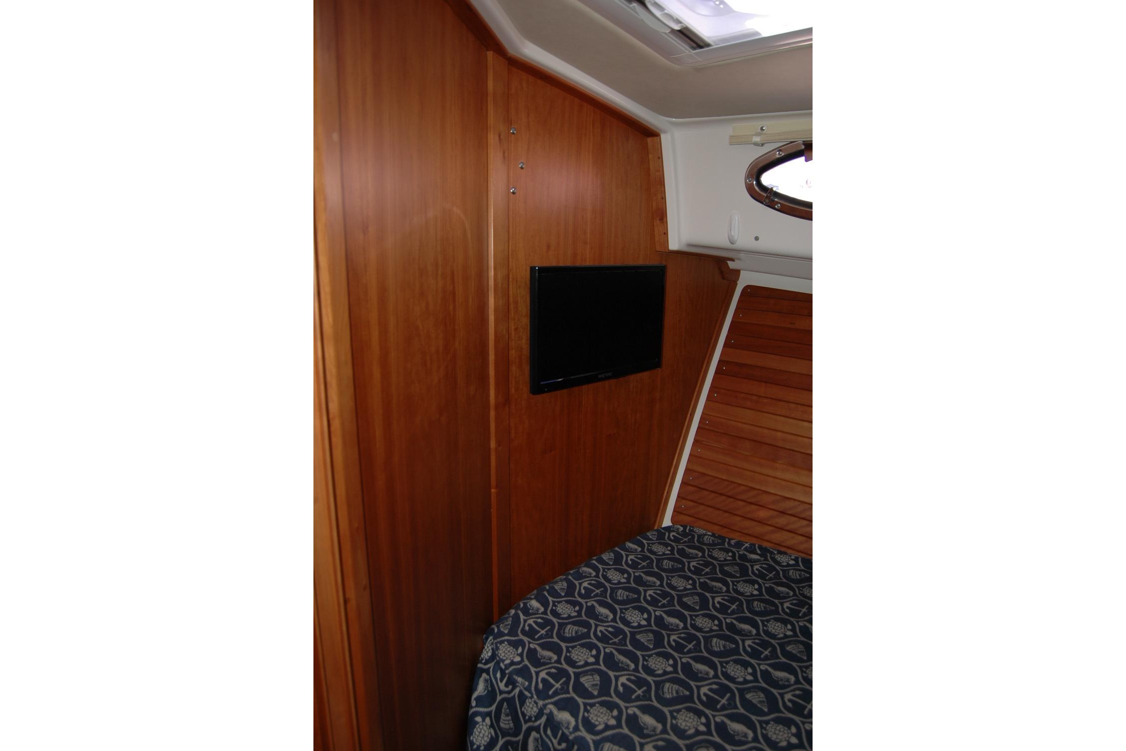 2015 Back Cove 37 cabin interior with wood paneling and mounted TV.