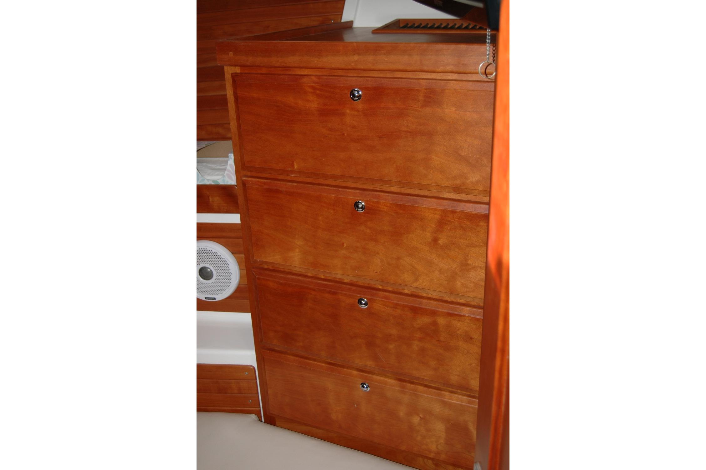 Wooden cabinet with four drawers inside a 2015 Back Cove 37 boat interior.