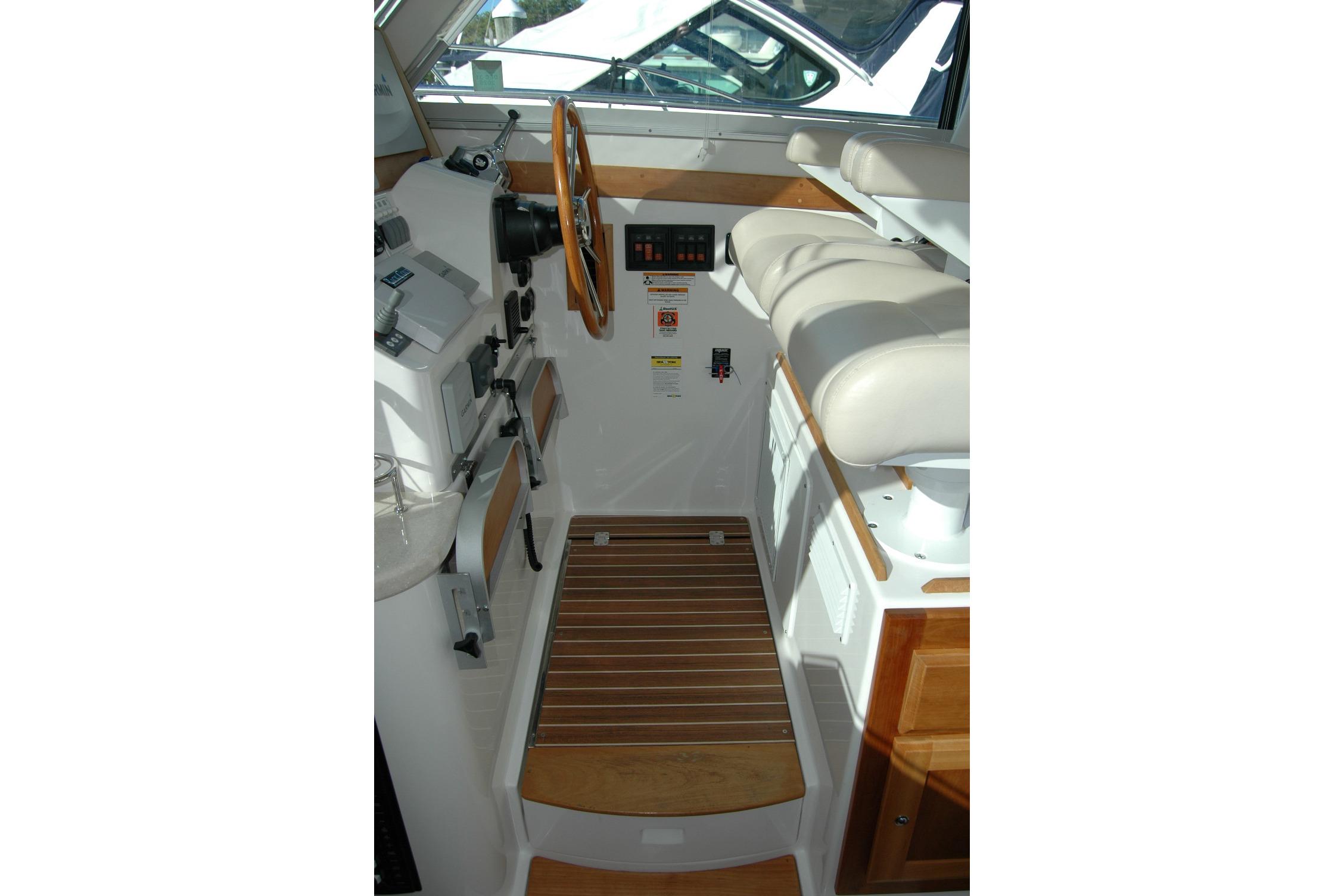 Interior helm of 2015 Back Cove 37 boat with wooden accents and controls.