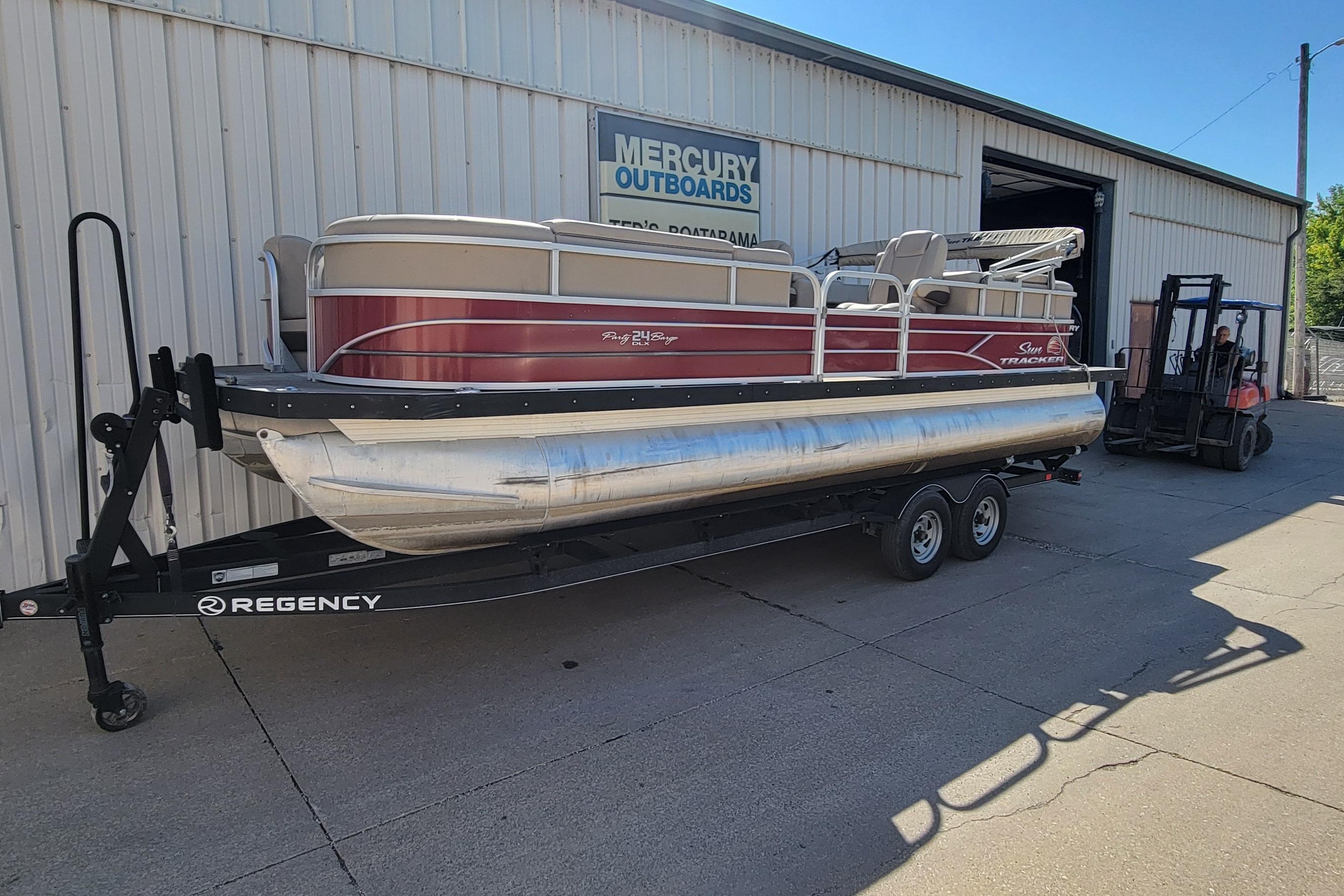 2019 Sun Tracker Party Barge 24 DLX pontoon boat on trailer outside Mercury Outboards.