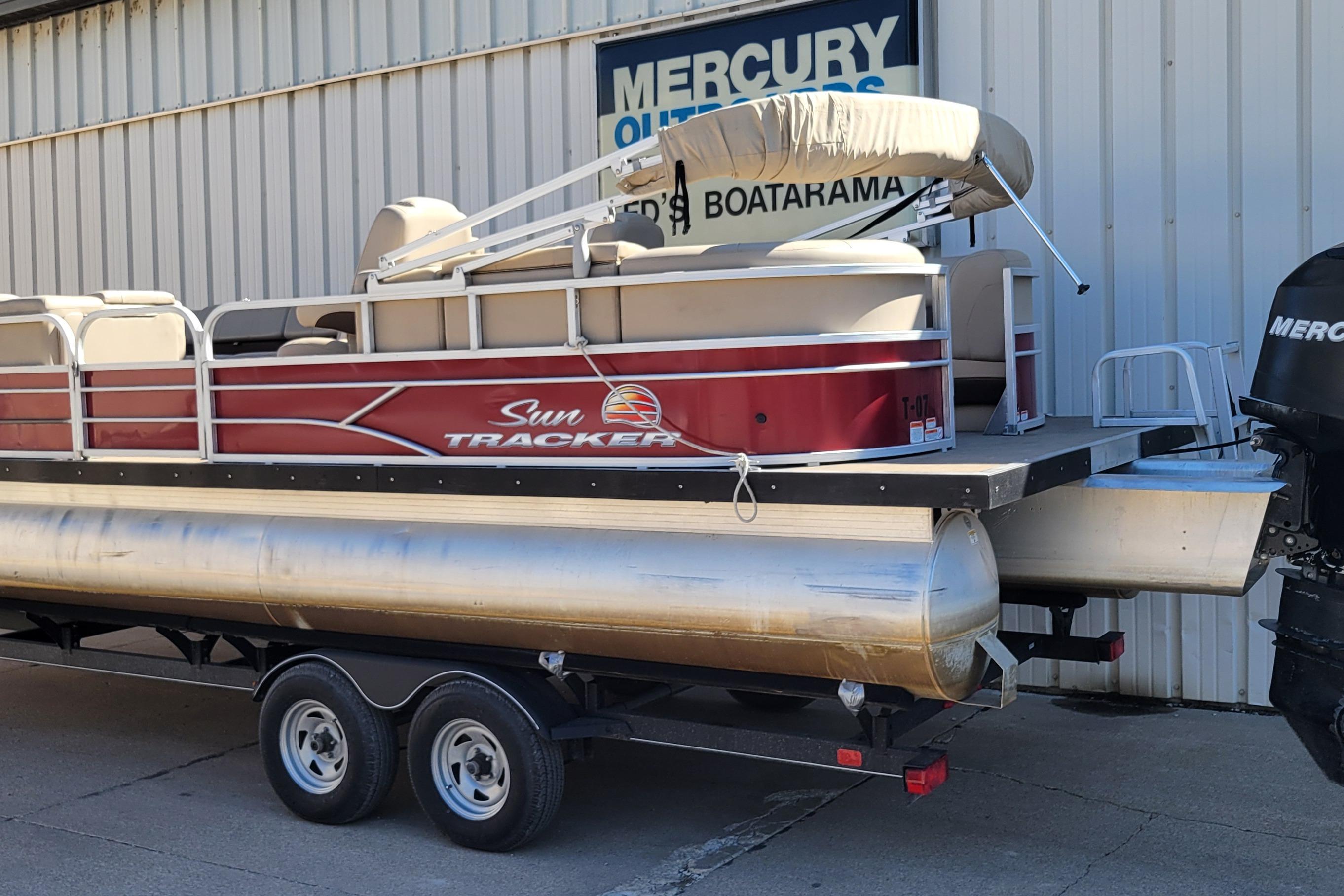 2019 Sun Tracker Party Barge 24 DLX pontoon boat on trailer, parked outside.