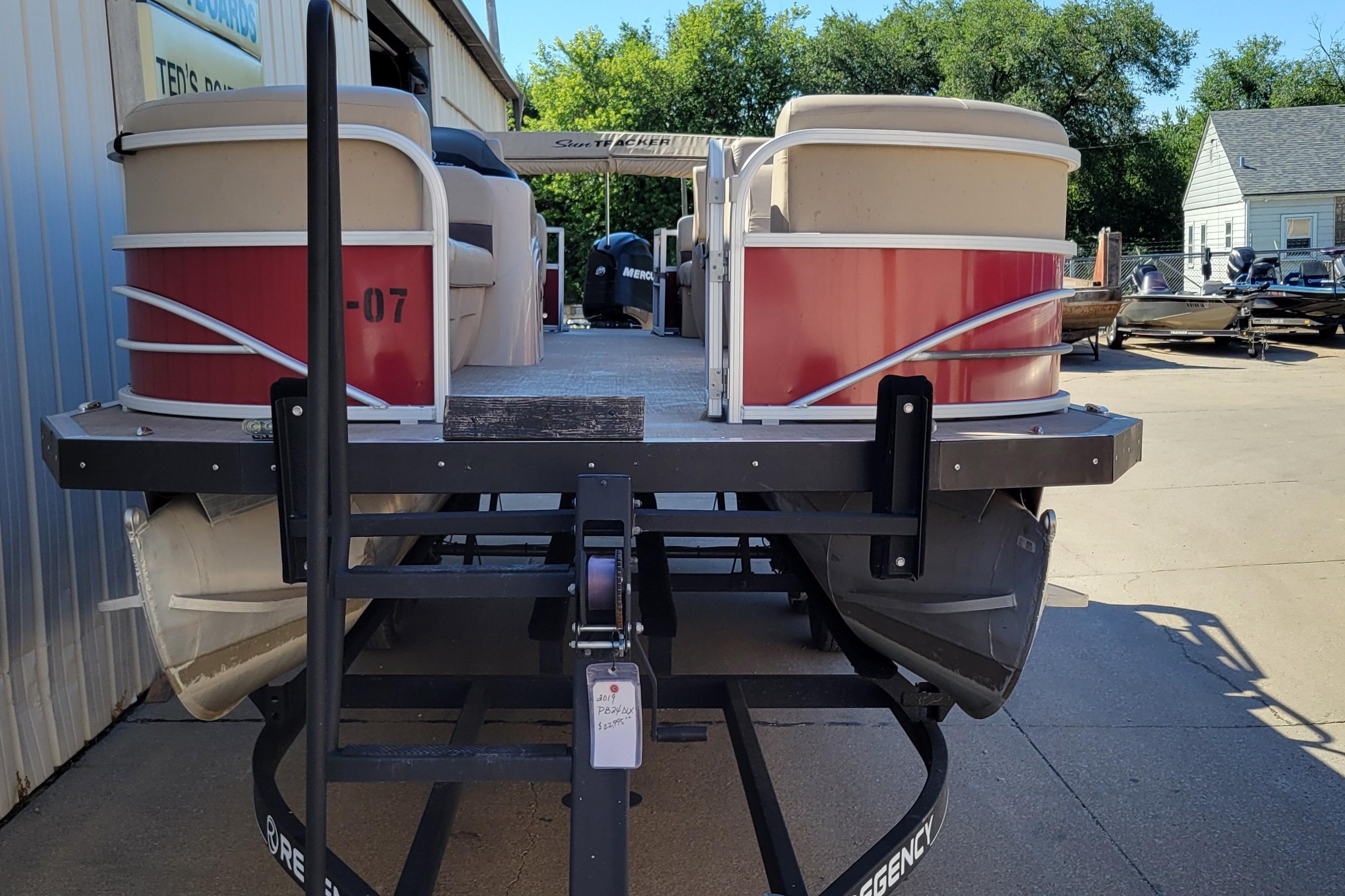 2019 Sun Tracker Party Barge 24 DLX pontoon boat on trailer, outdoor setting.
