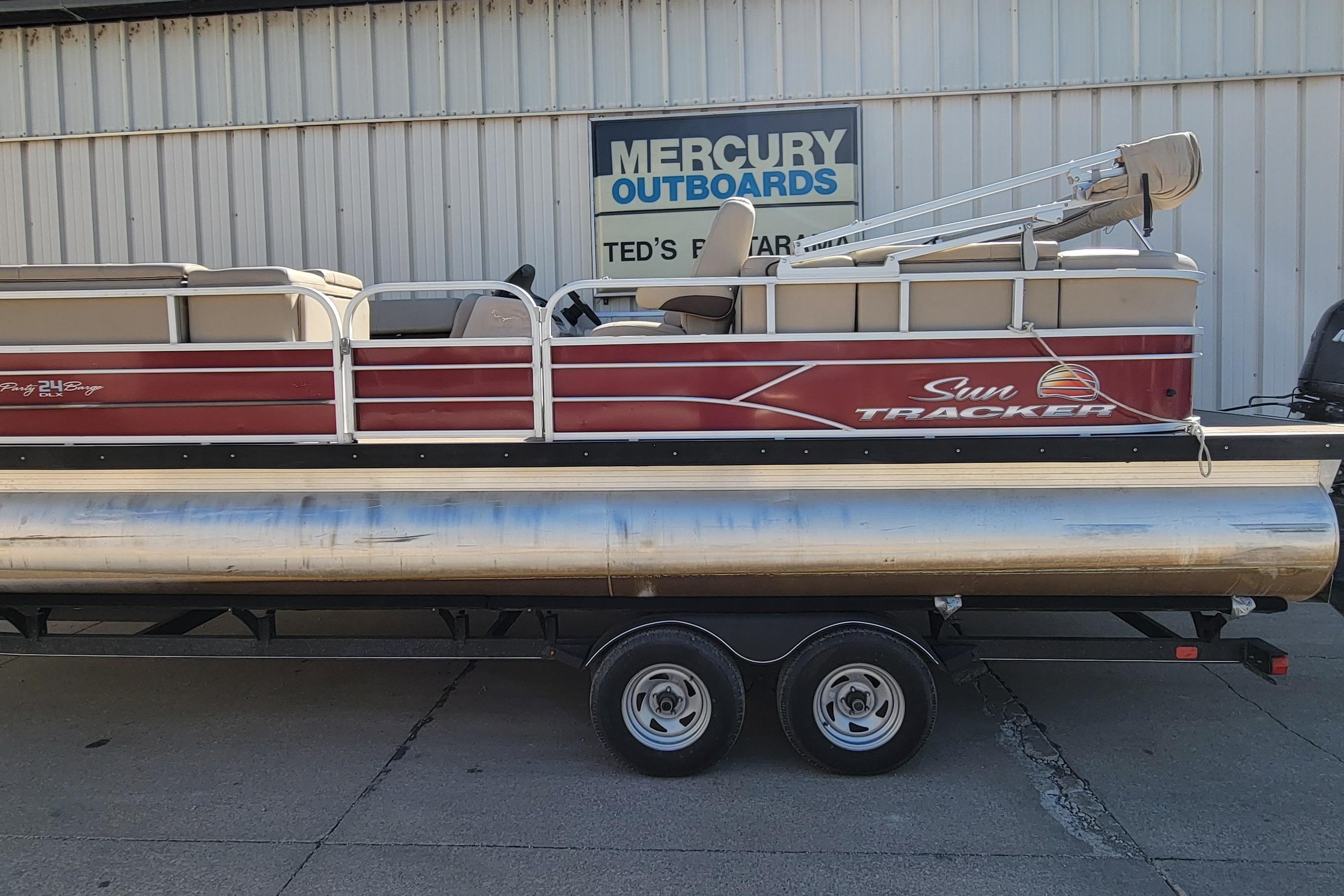 2019 Sun Tracker Party Barge 24 DLX pontoon boat on trailer, parked outside.