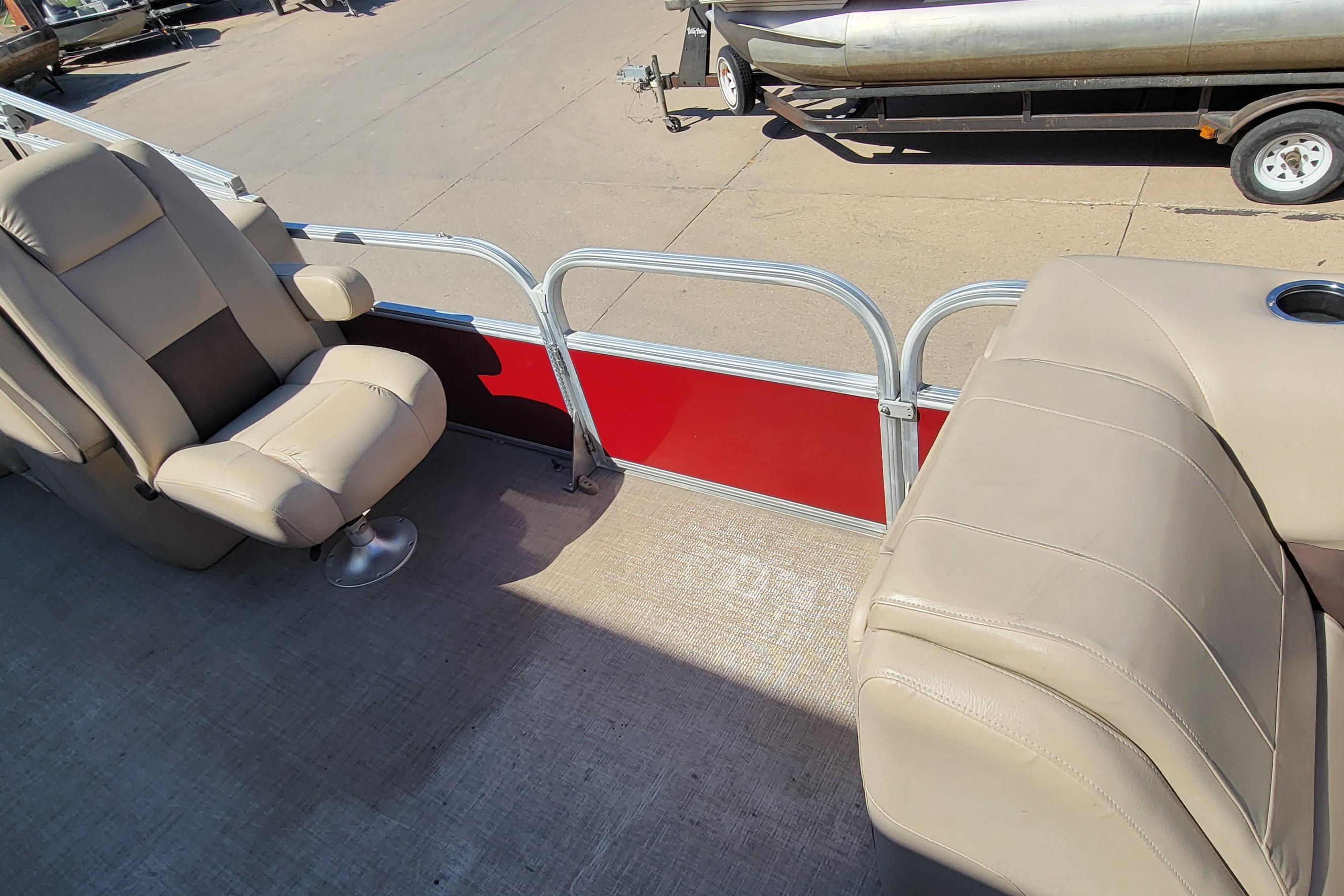 2019 Sun Tracker Party Barge 24 DLX interior with beige seating and red panel.
