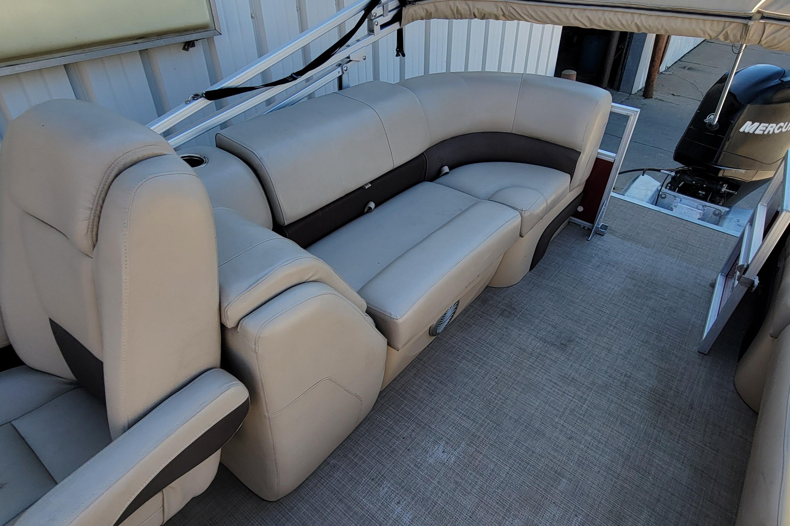2019 Sun Tracker Party Barge 24 DLX interior with beige seating and Mercury outboard motor.