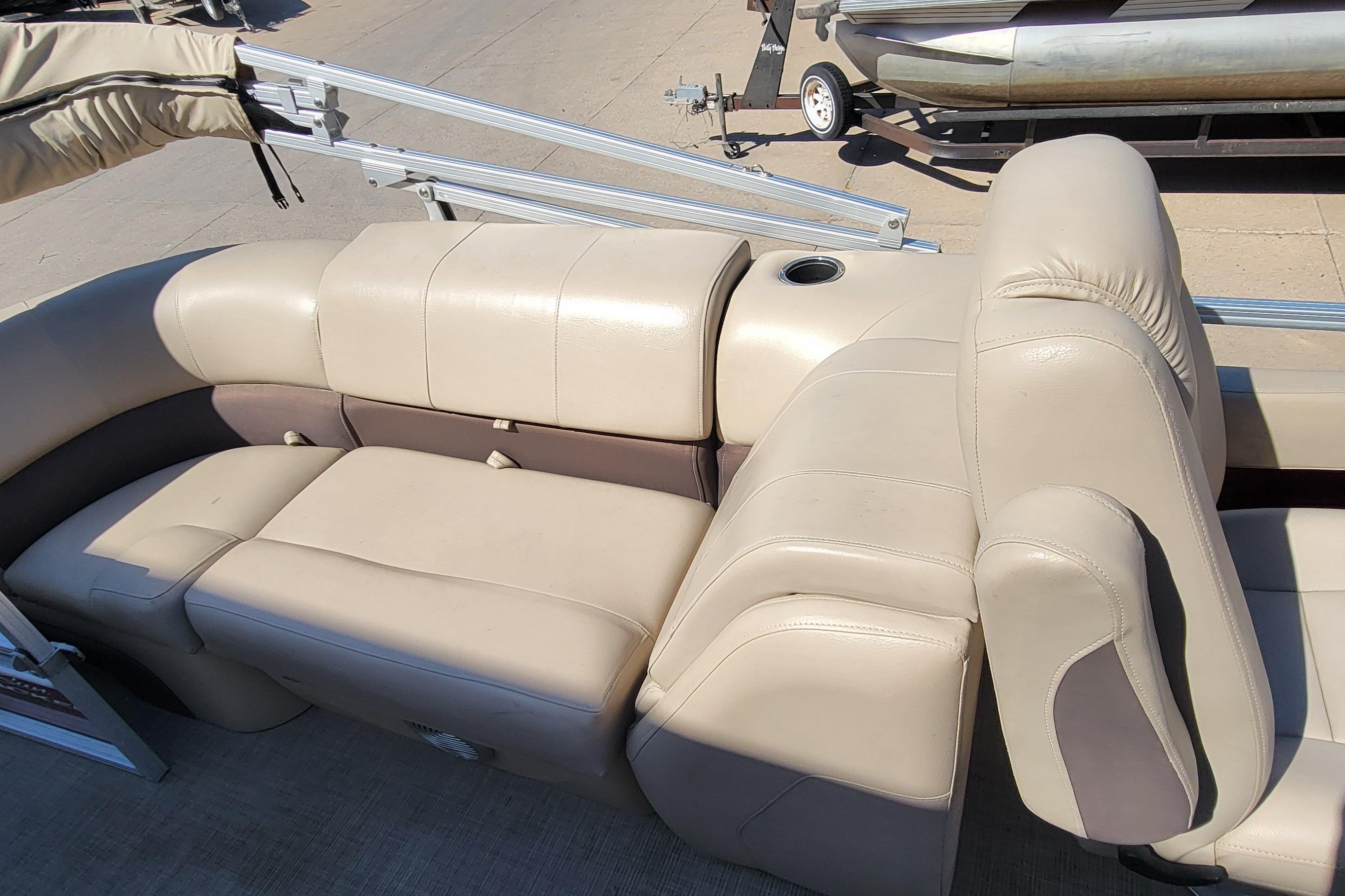 2019 Sun Tracker Party Barge 24 DLX, beige seating, cup holder, outdoor setting.
