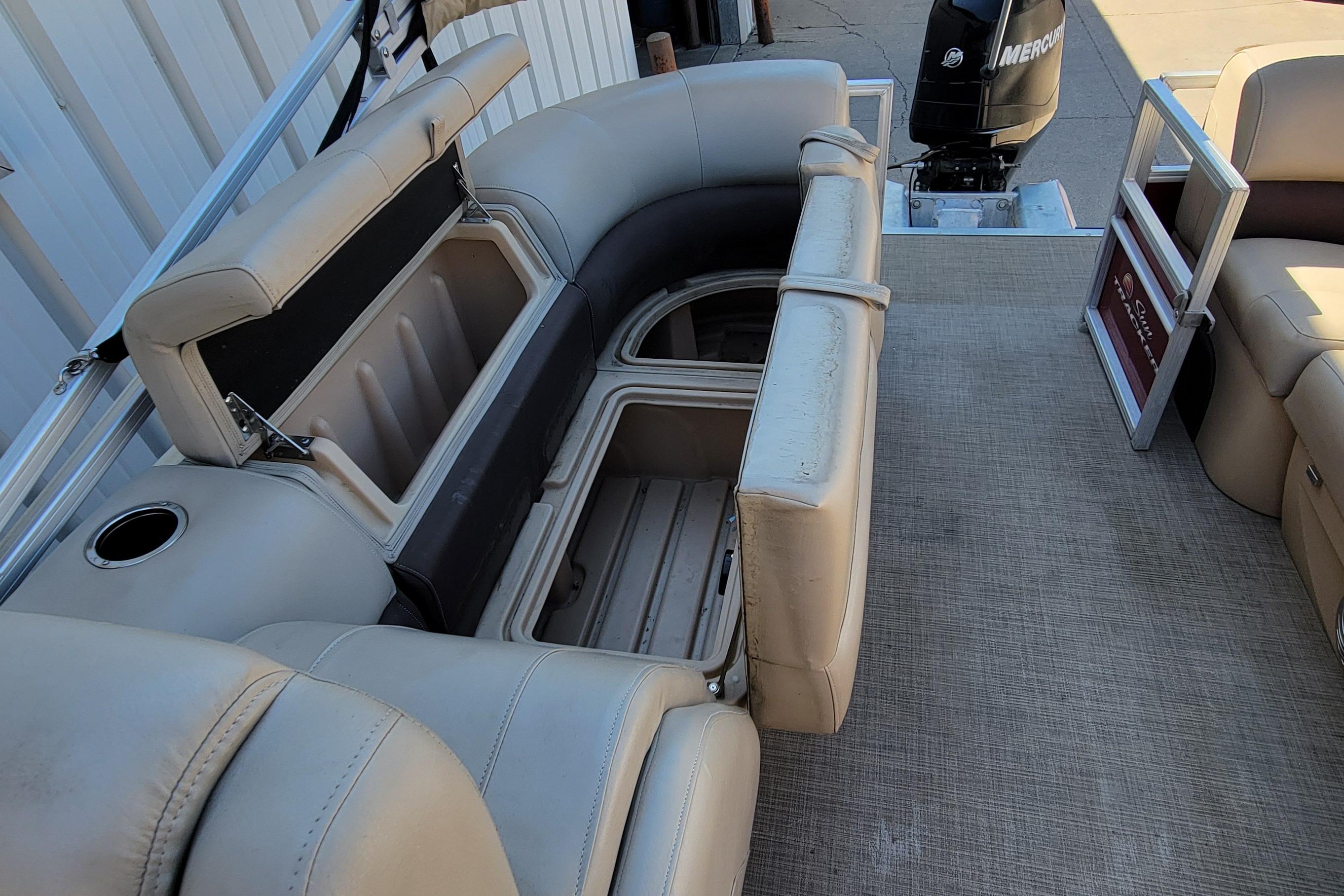 2019 Sun Tracker Party Barge 24 DLX interior with open storage compartments and seating.