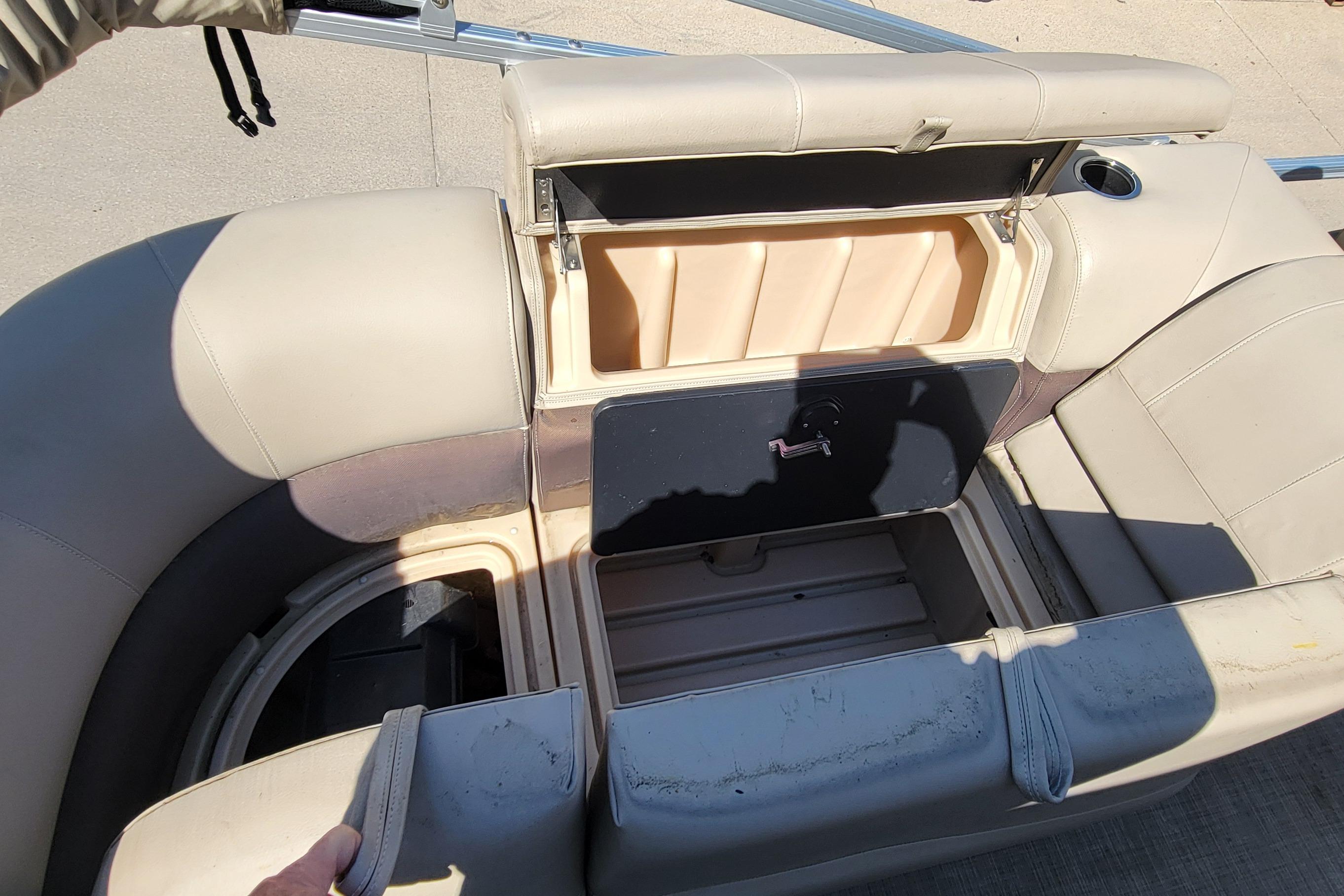 2019 Sun Tracker Party Barge 24 DLX storage compartment with open seat and cup holder.