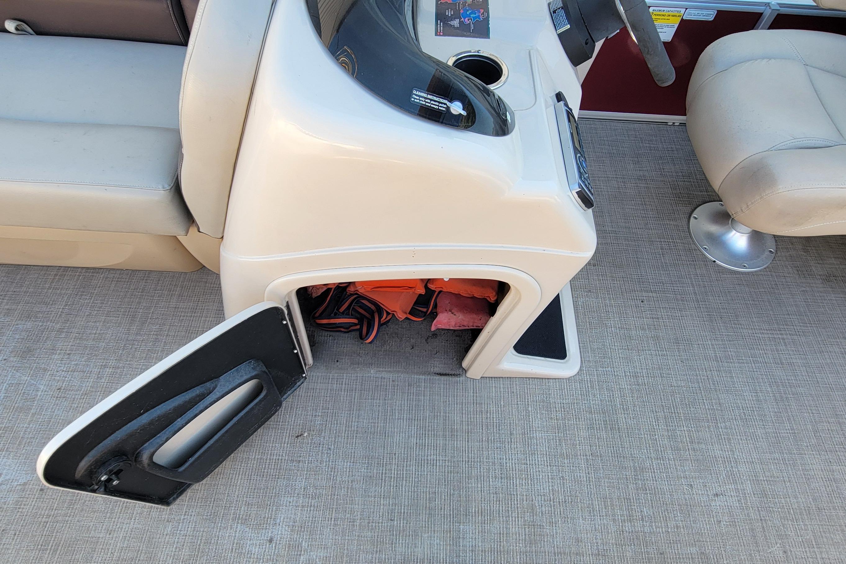 2019 Sun Tracker Party Barge 24 DLX interior with open storage compartment.