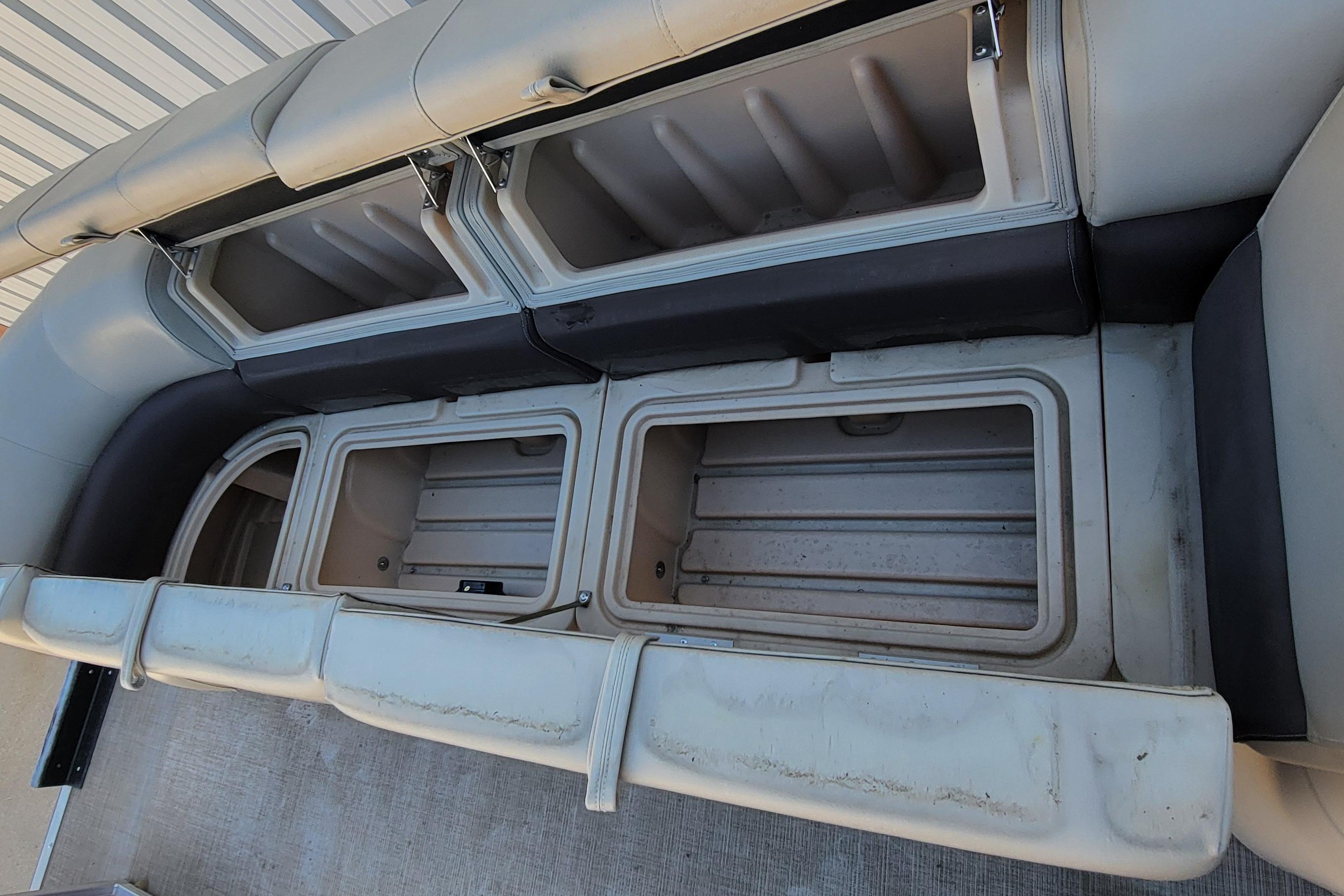 2019 Sun Tracker Party Barge 24 DLX storage compartments, open and empty, showcasing interior space.