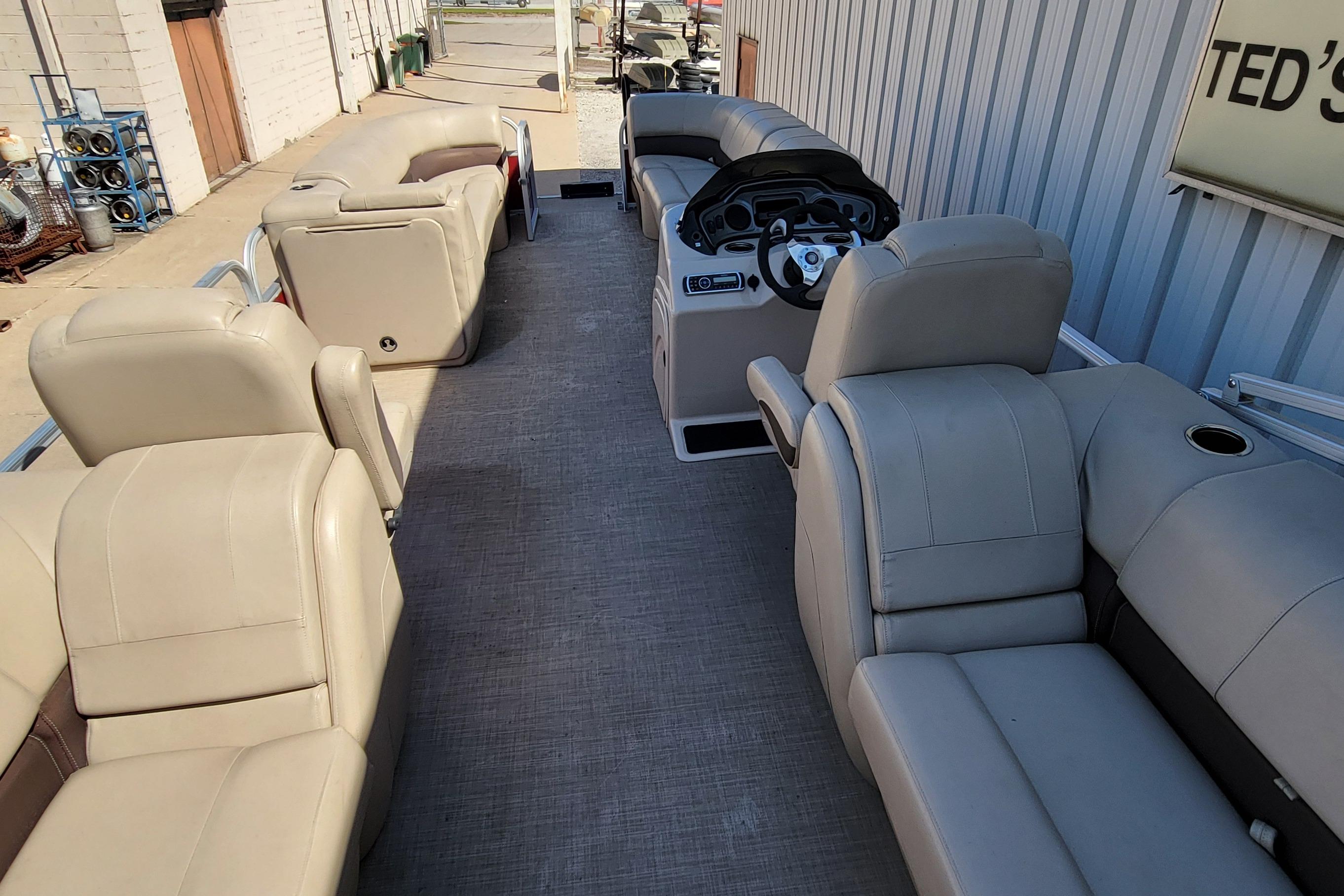 2019 Sun Tracker Party Barge 24 DLX interior with beige seating and steering console.