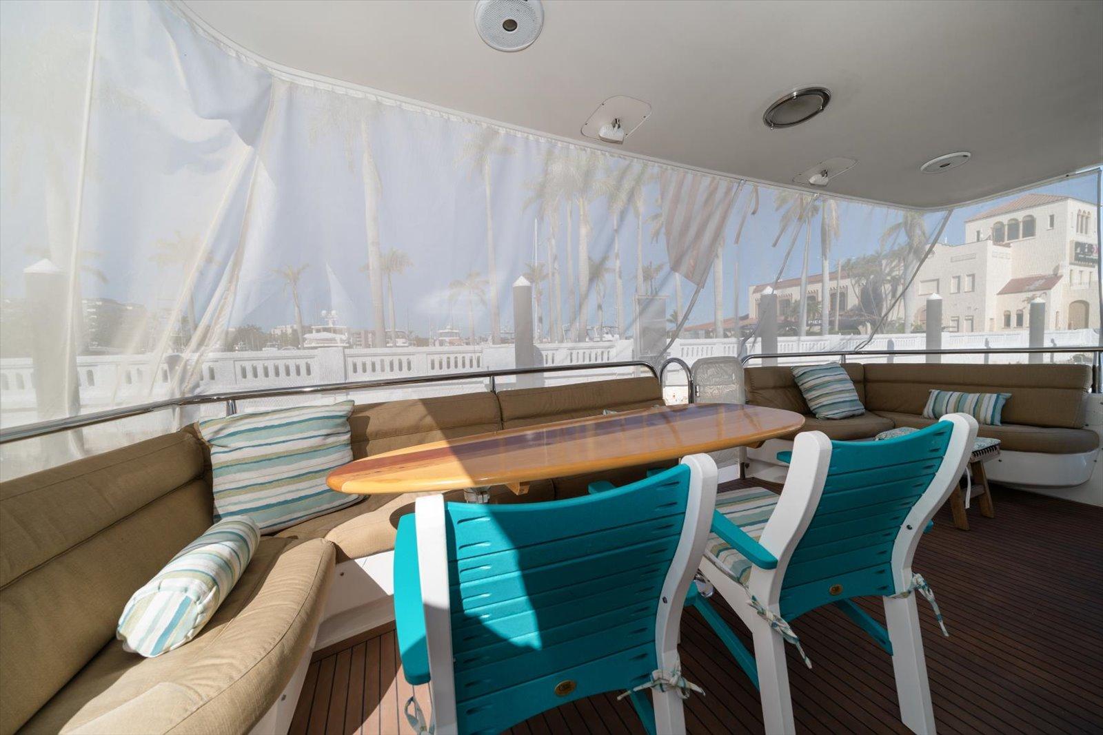 Lazzara-EB 76 1997-Octopi FL-US-Spacious deck seating on 1997 Lazzara EB 76 yacht with teal chairs and wooden table.-9736767 | Thumbnail