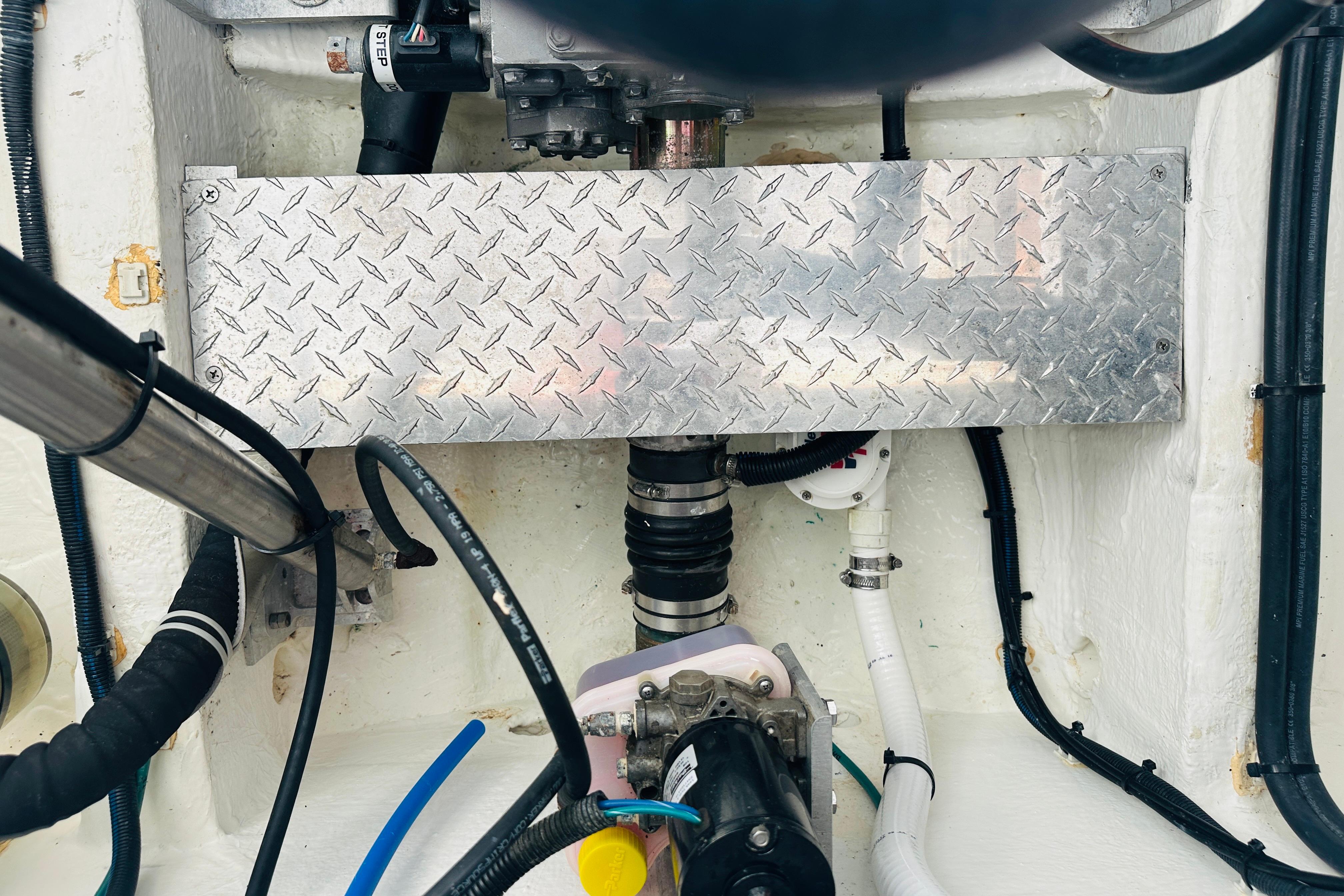 Engine compartment of a 2017 Back Cove 32 boat, featuring various hoses and metal components.