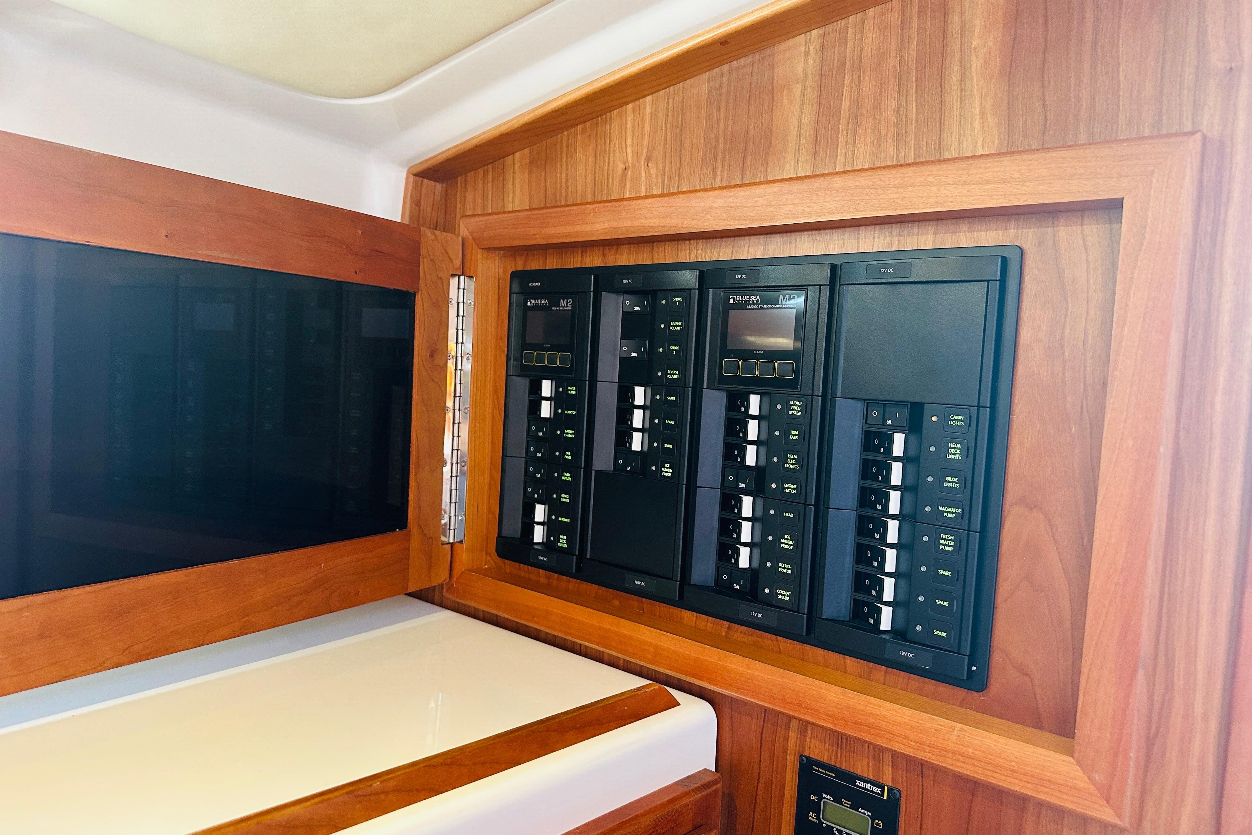 Electrical panel on 2017 Back Cove 32 boat, featuring wooden trim and control switches.