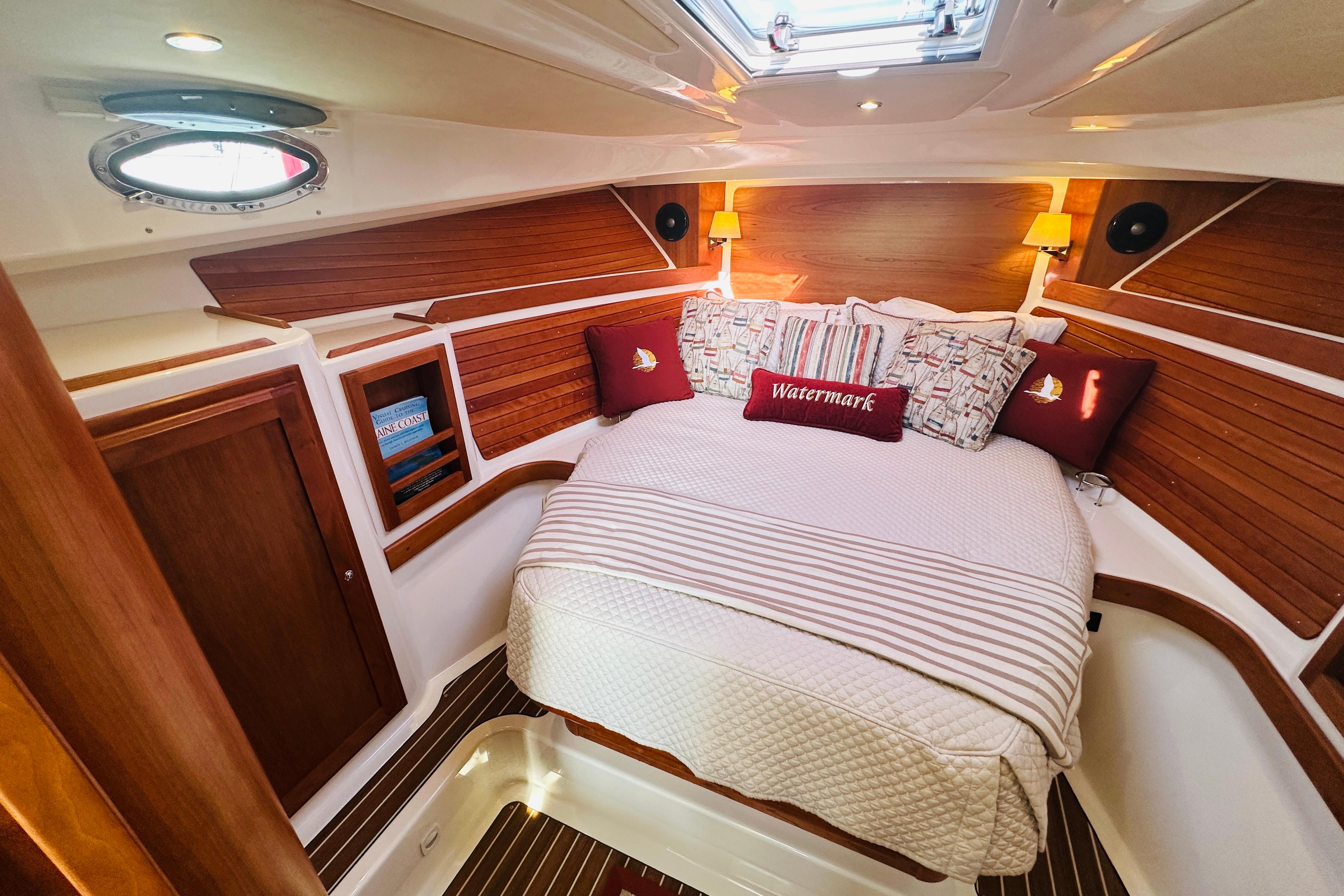 Luxurious cabin interior of 2017 Back Cove 32 yacht with cozy bedding and wooden accents.