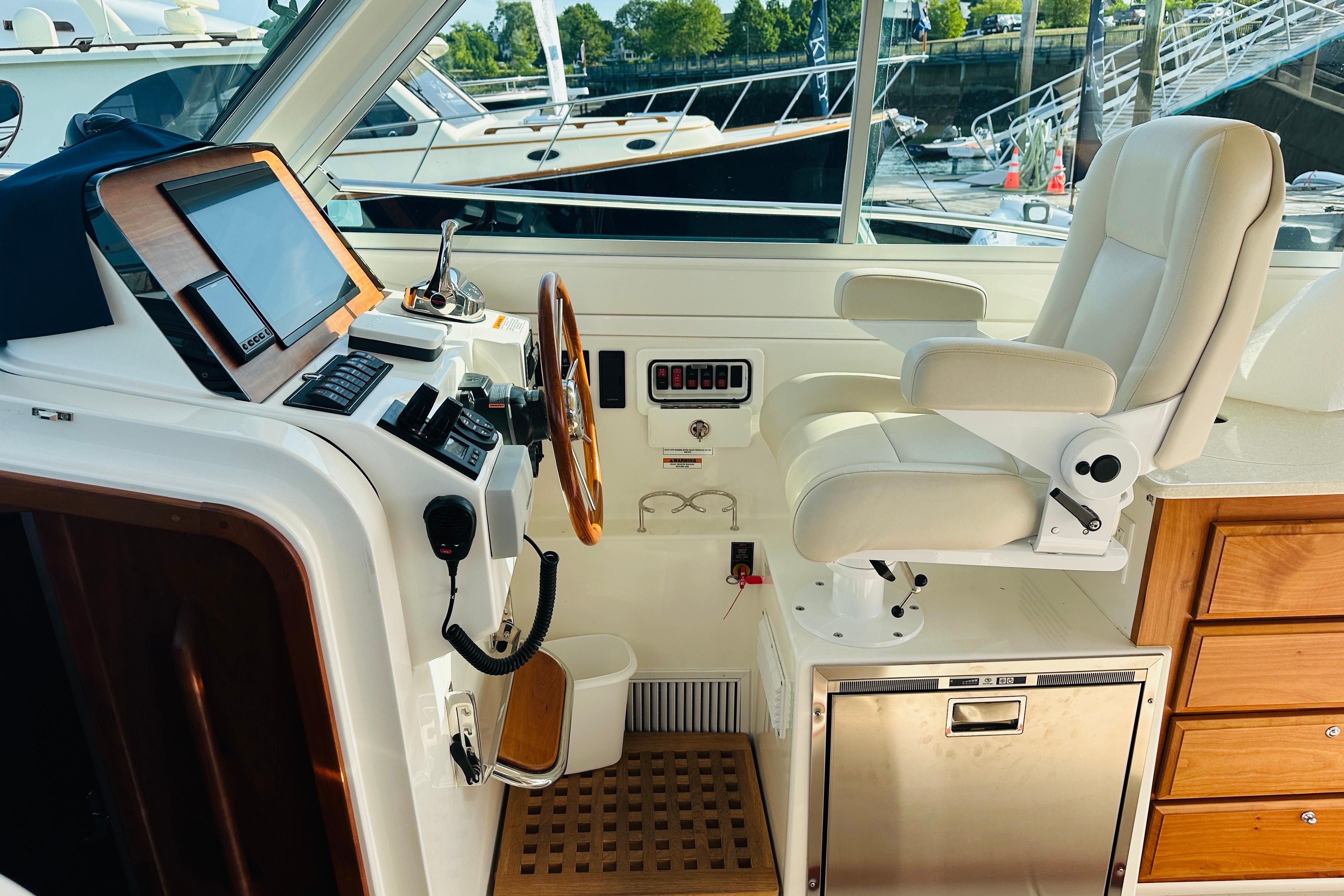 Helm station of 2017 Back Cove 32 boat with leather seat and navigation controls.