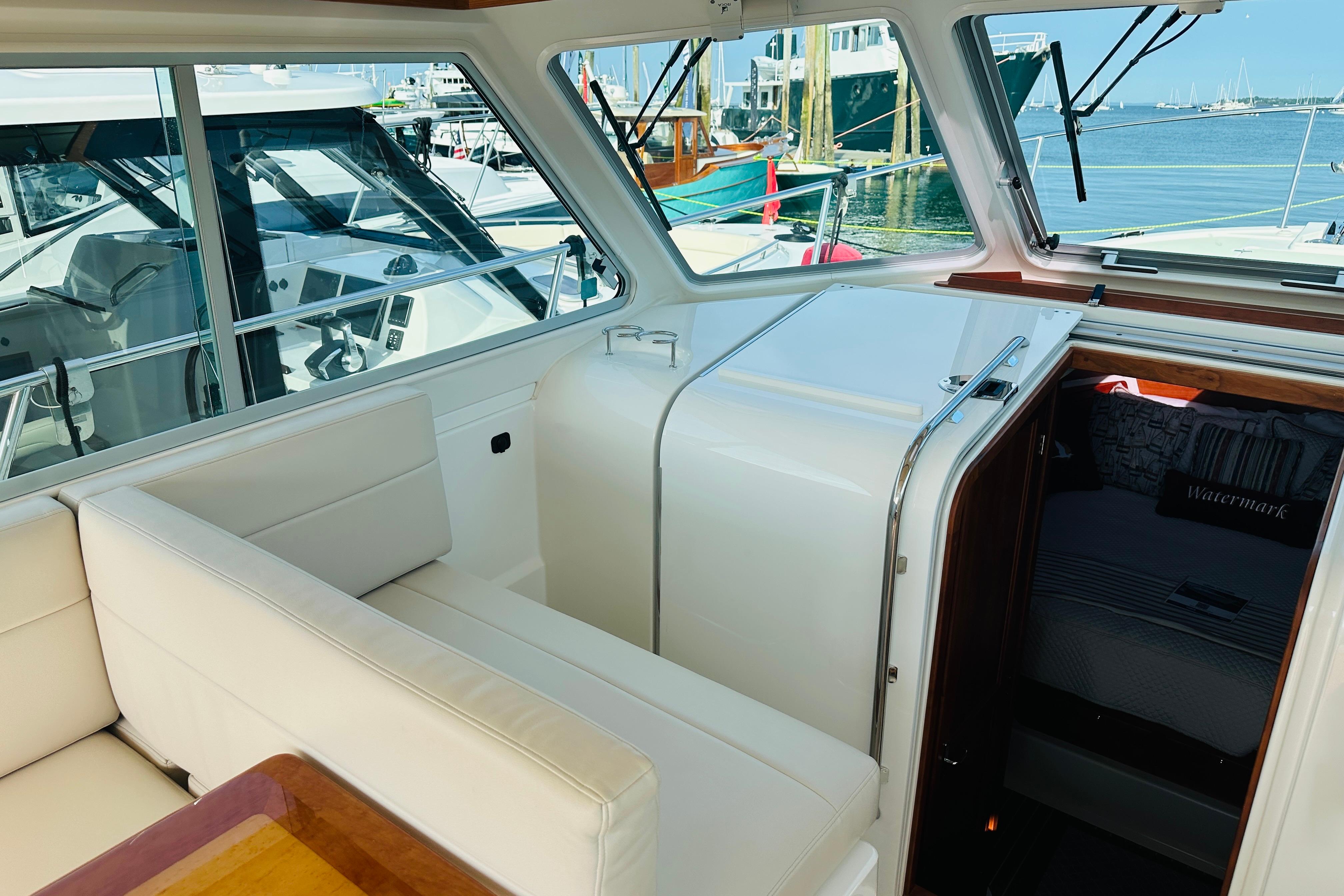 Interior of 2017 Back Cove 32 yacht with white seating and cabin entrance.