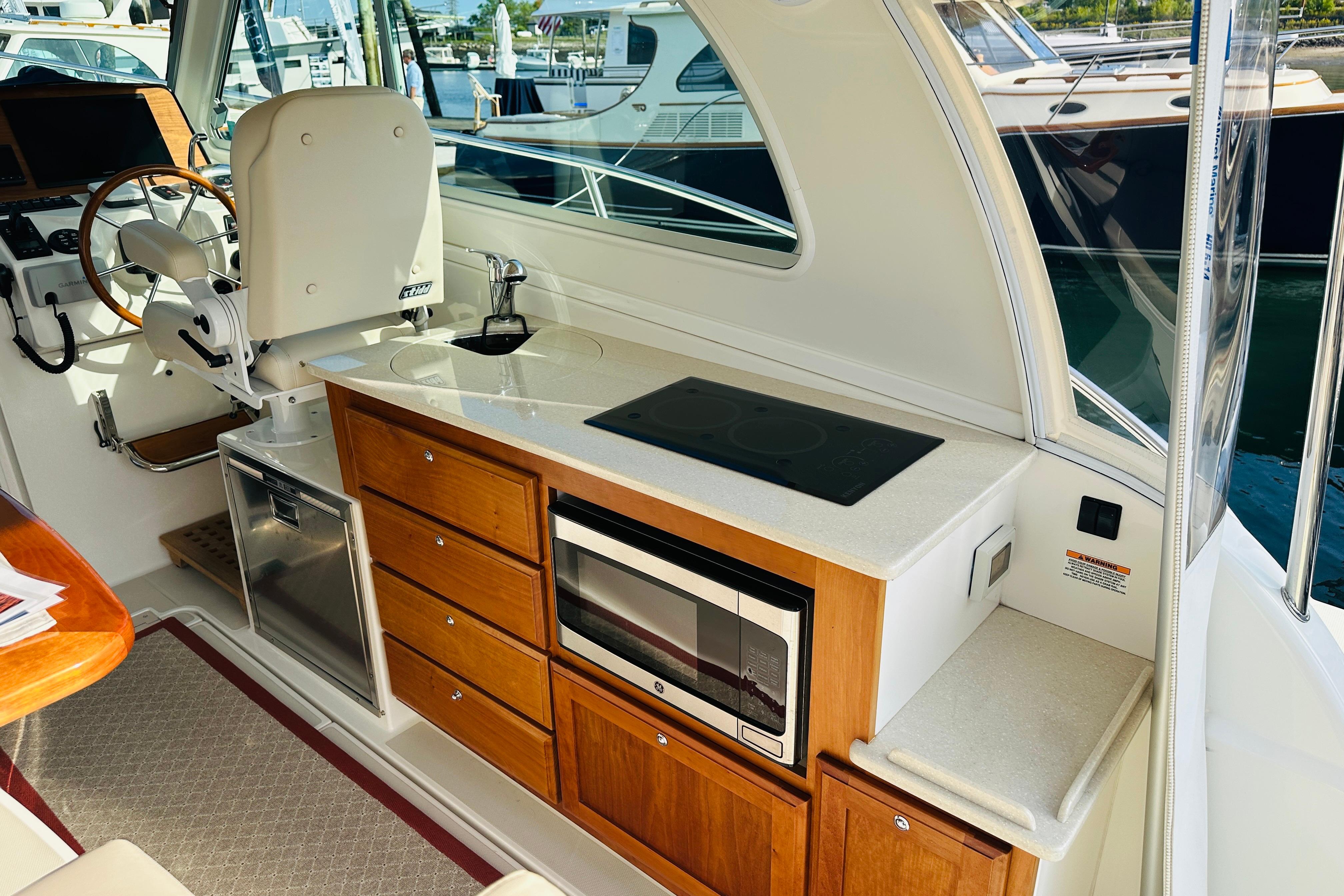 2017 Back Cove 32 yacht interior with helm, kitchenette, and modern amenities.