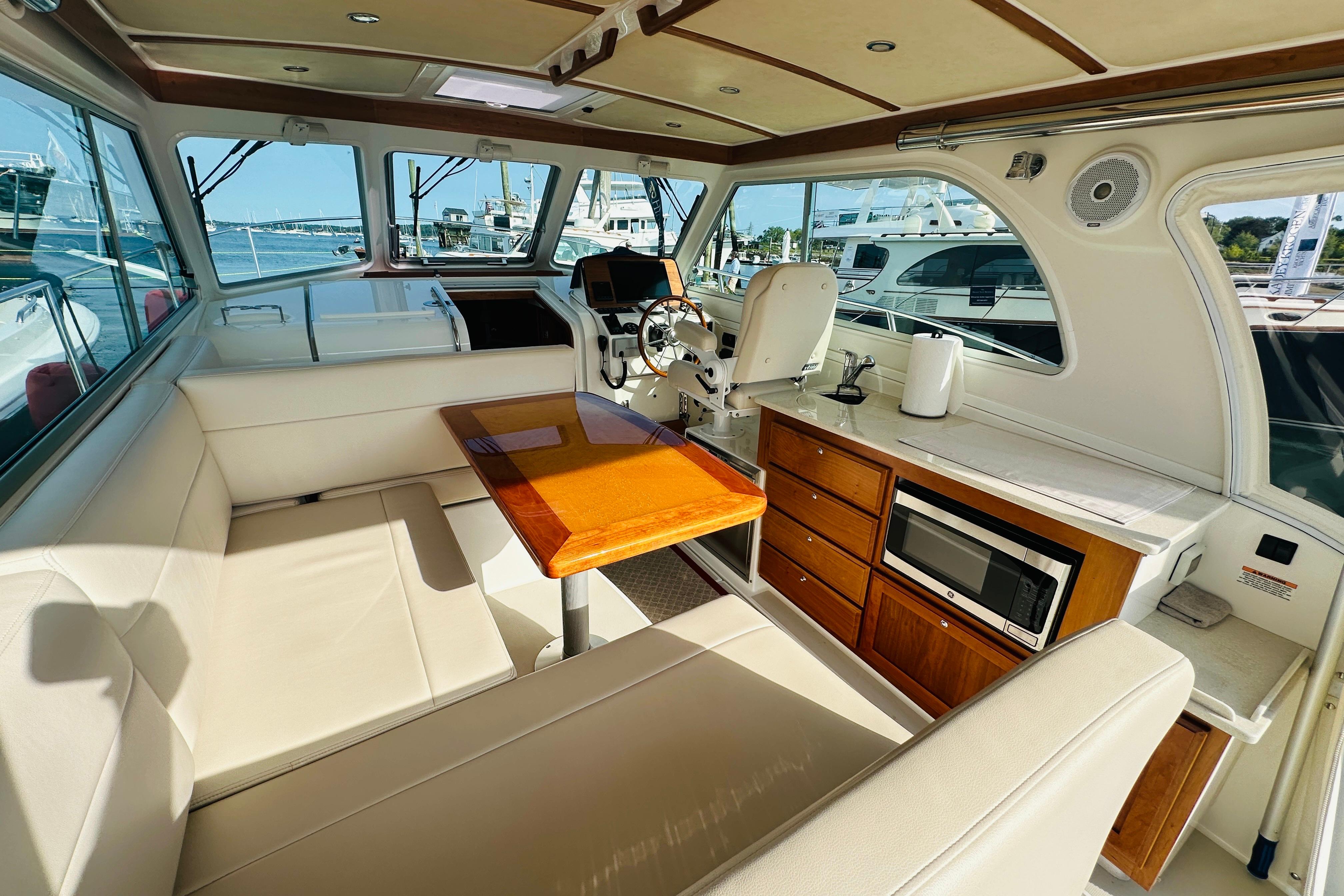 Interior of 2017 Back Cove 32 yacht with seating, table, and kitchenette.