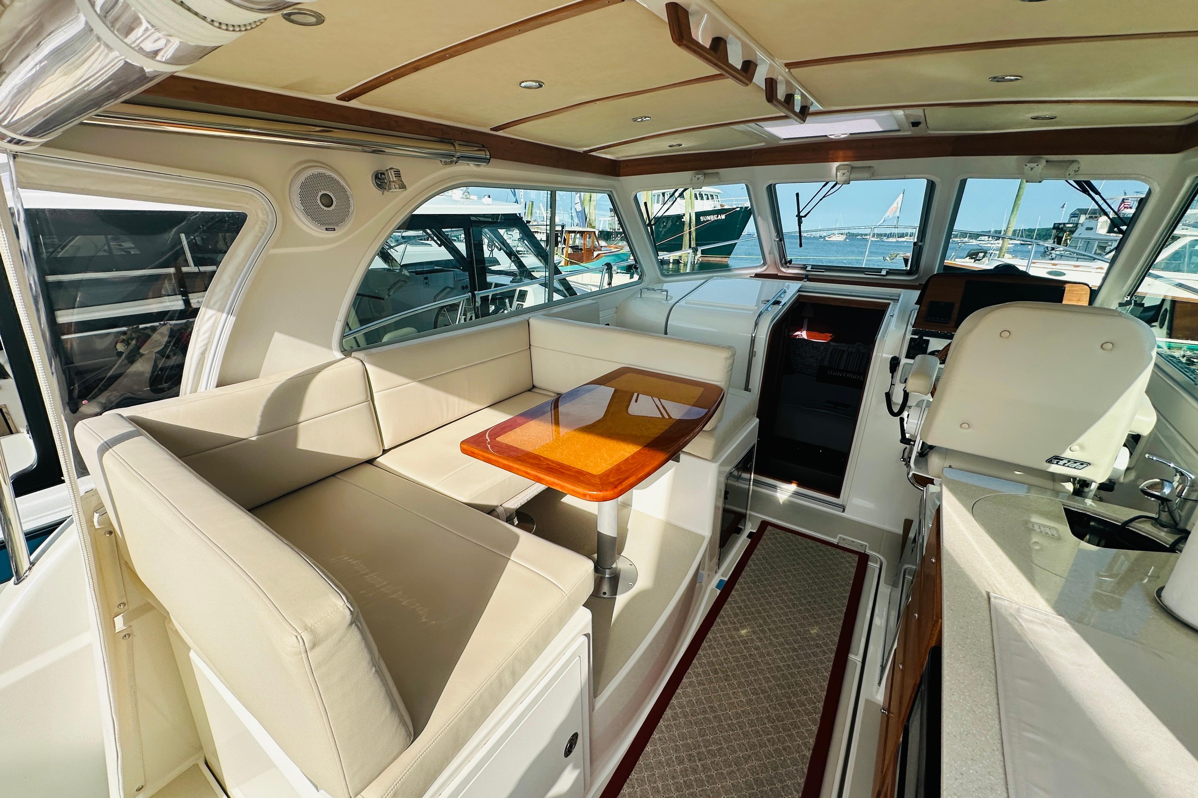 Interior of 2017 Back Cove 32 yacht with seating and helm, docked at marina.
