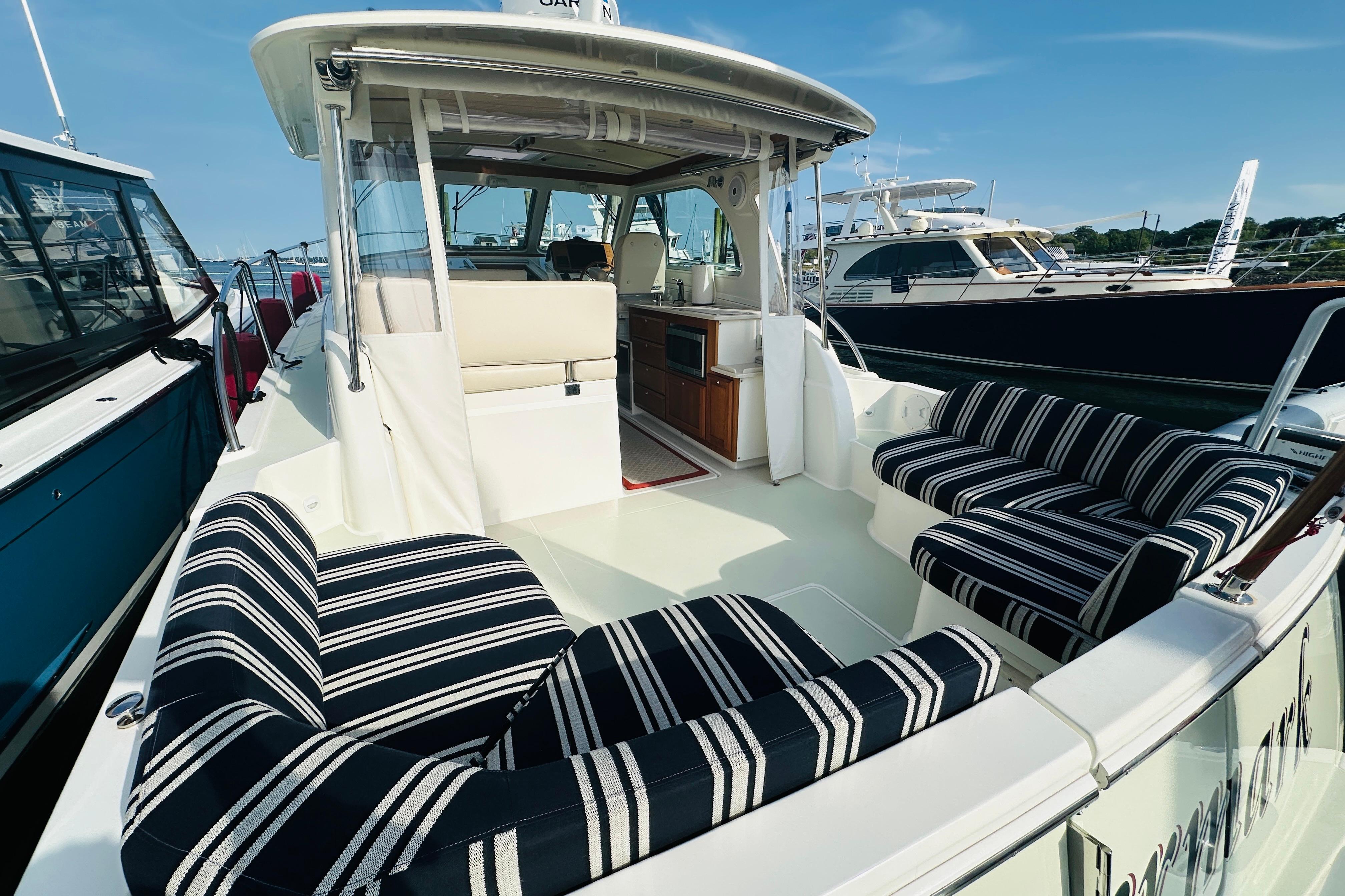 2017 Back Cove 32 boat with striped seating and open cockpit, docked at marina.