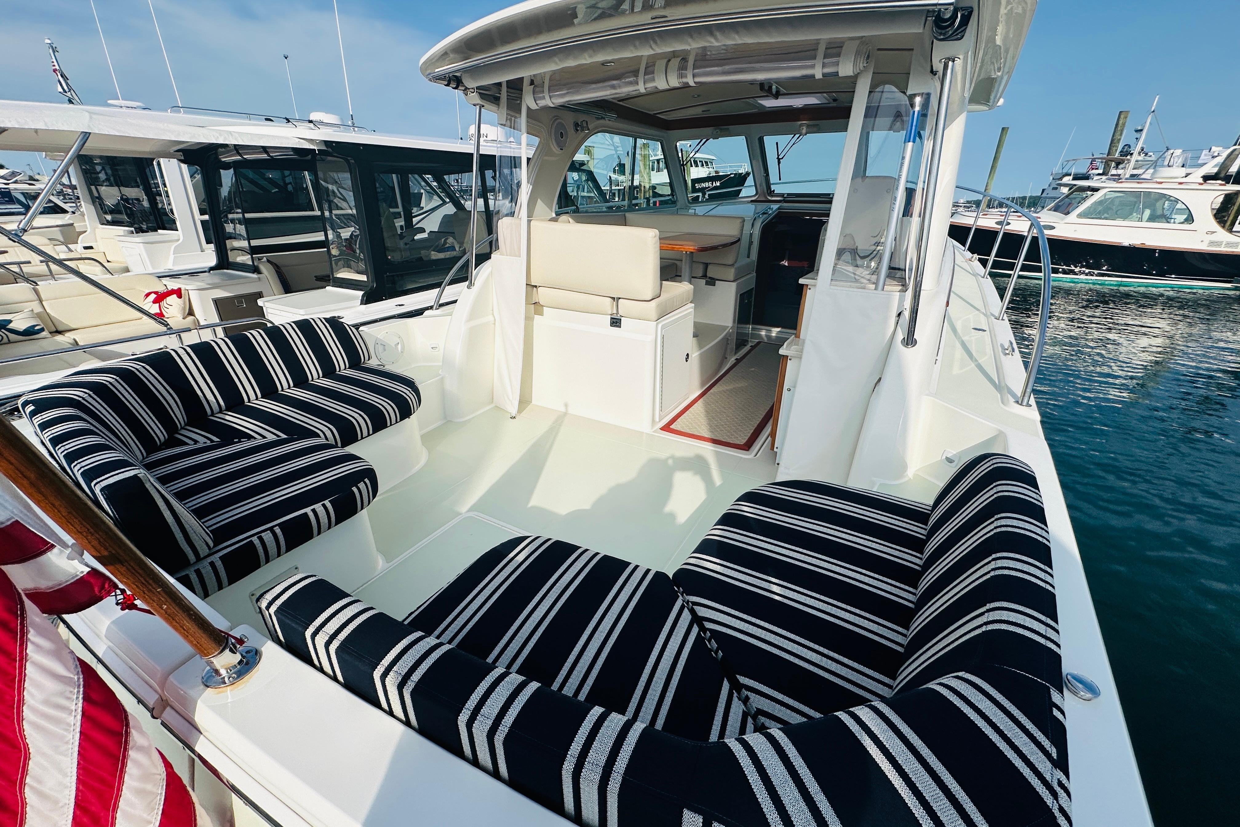 2017 Back Cove 32 boat with striped seating, docked at a marina.