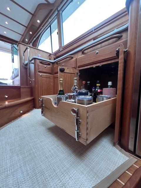 2021 Sabre 45 Salon Express interior with open drawer displaying beverages and glasses.