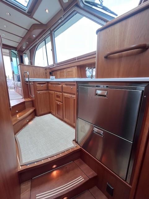 Interior of 2021 Sabre 45 Salon Express yacht with wooden cabinetry and stainless steel appliances.